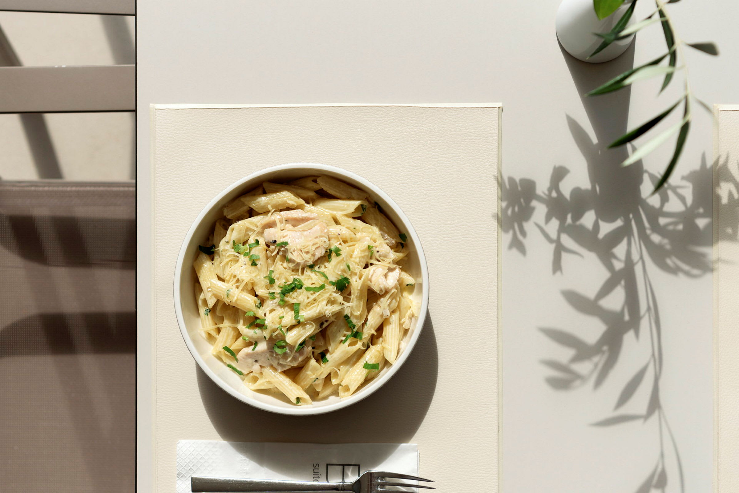 En tallerken med pasta serveret på et bord. (AI-genereret tekst)