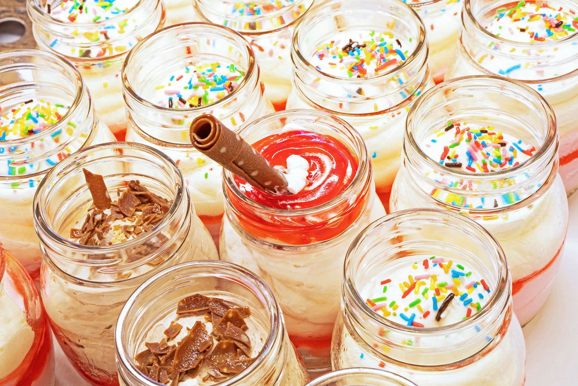 Glasbægre fyldt med dessert toppet med krymmel og chokolade. (AI-genereret tekst)