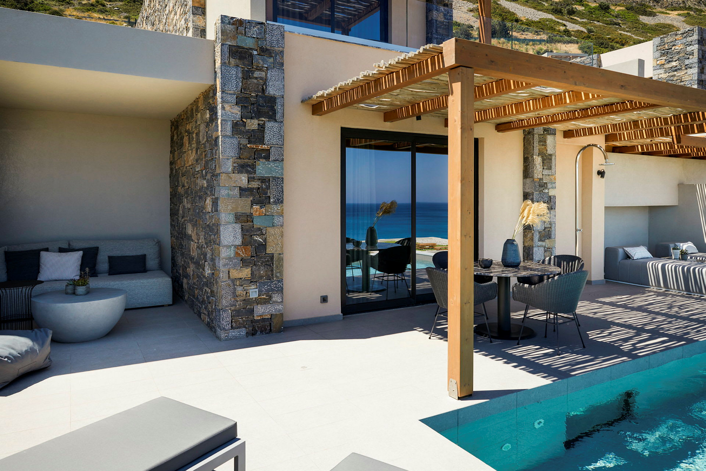 Moderne hus med pool, terrasse og udsigt over havet. (AI-genereret tekst)