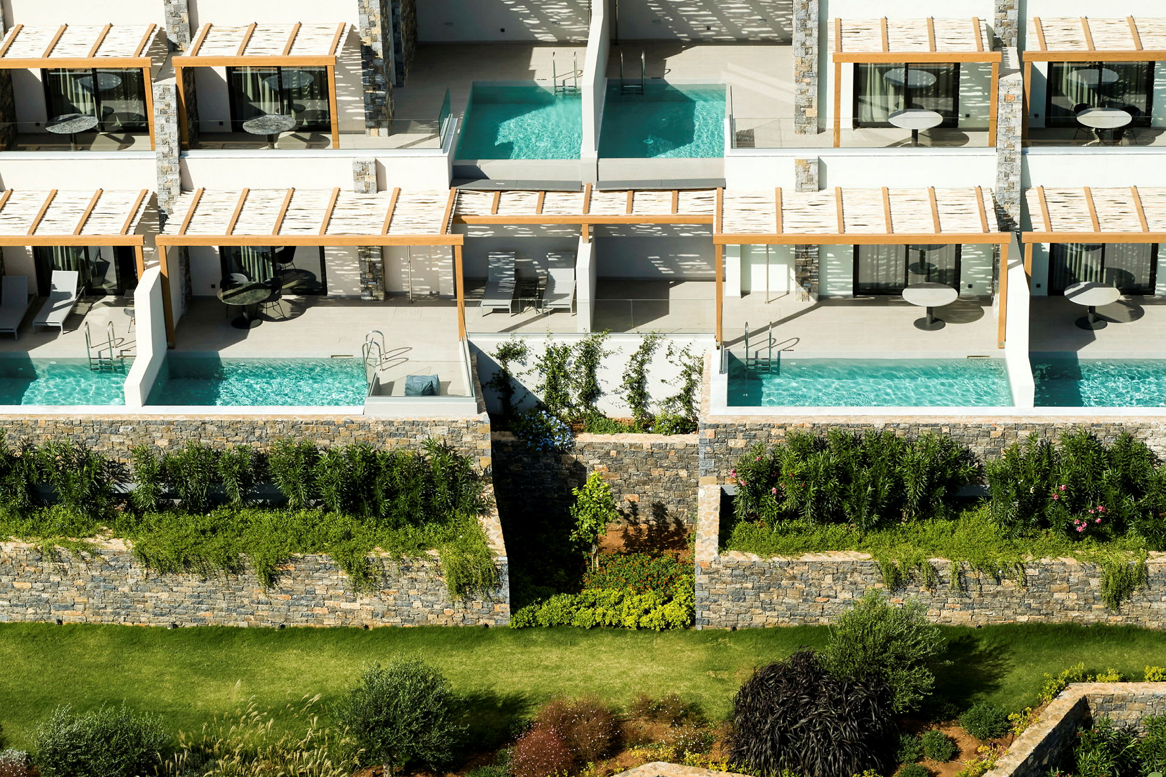 Flere lejligheder med private pools og terrasser, omgivet af grønne områder. (AI-genereret tekst)