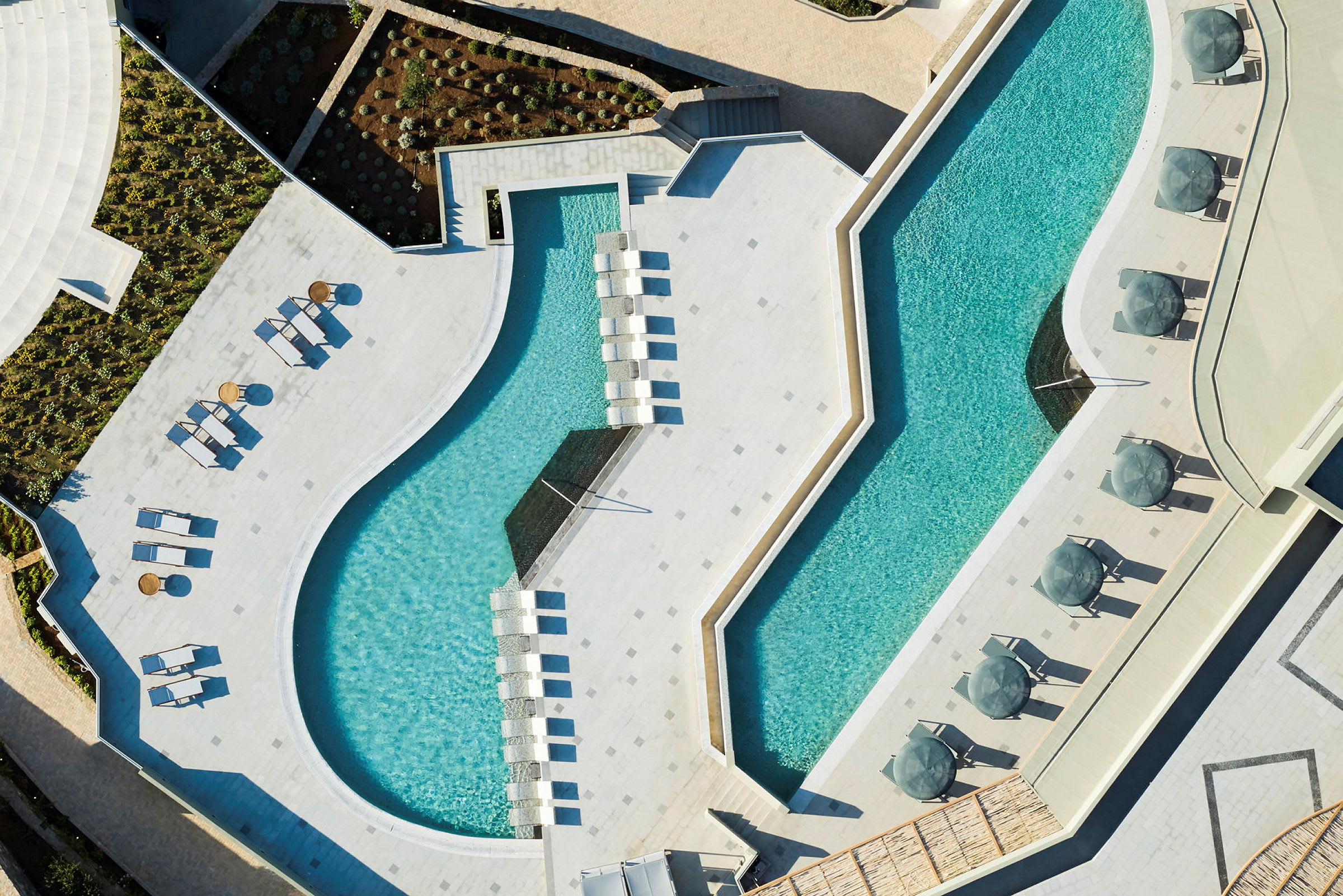 Luftfoto over en moderne pool med solsenge og parasoller. (AI-genereret tekst)