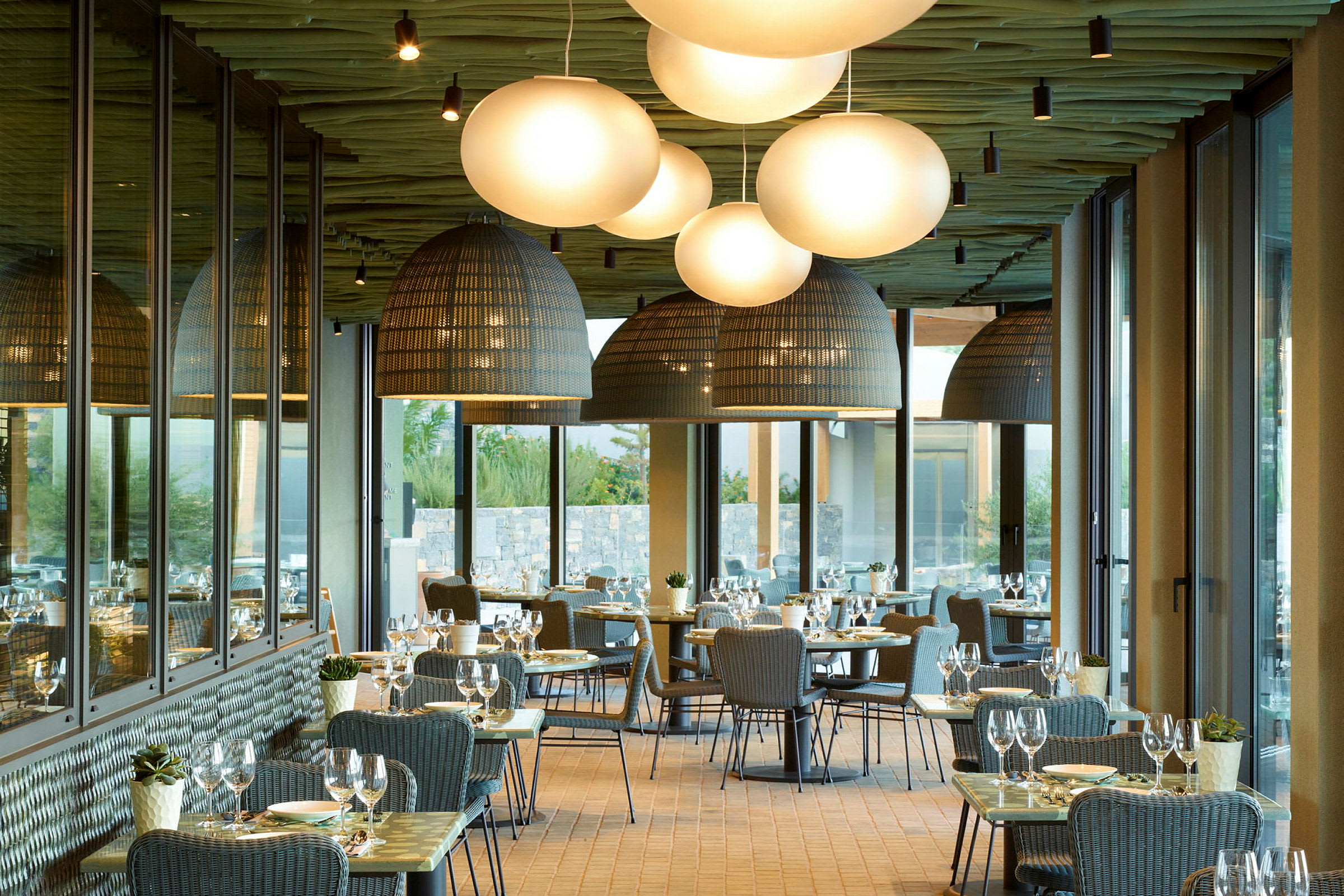 Restaurant med dækkede borde og store lamper. (AI-genereret tekst)