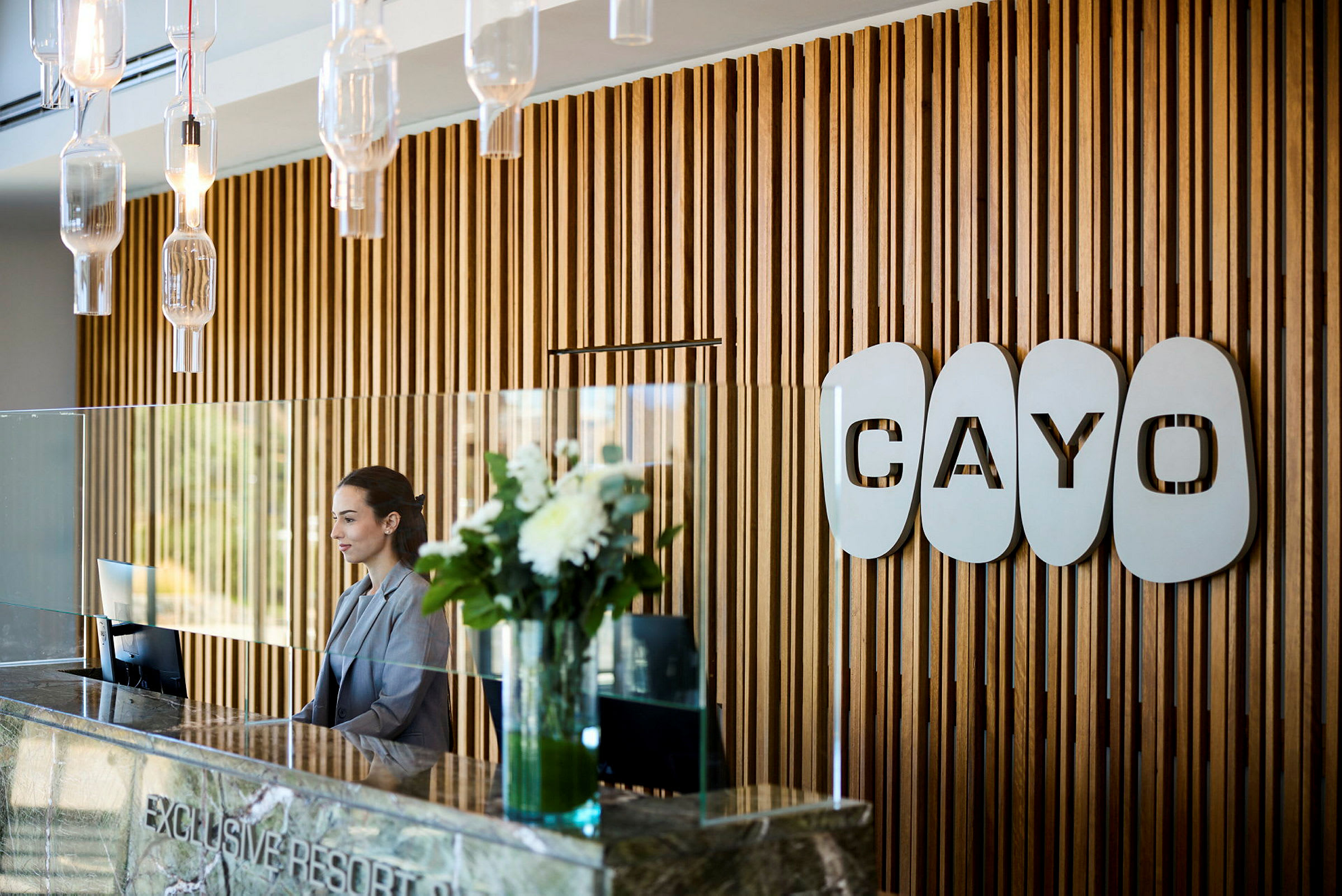 Reception med vægge af træpaneler og logoet 'Cayo'. (AI-genereret tekst)