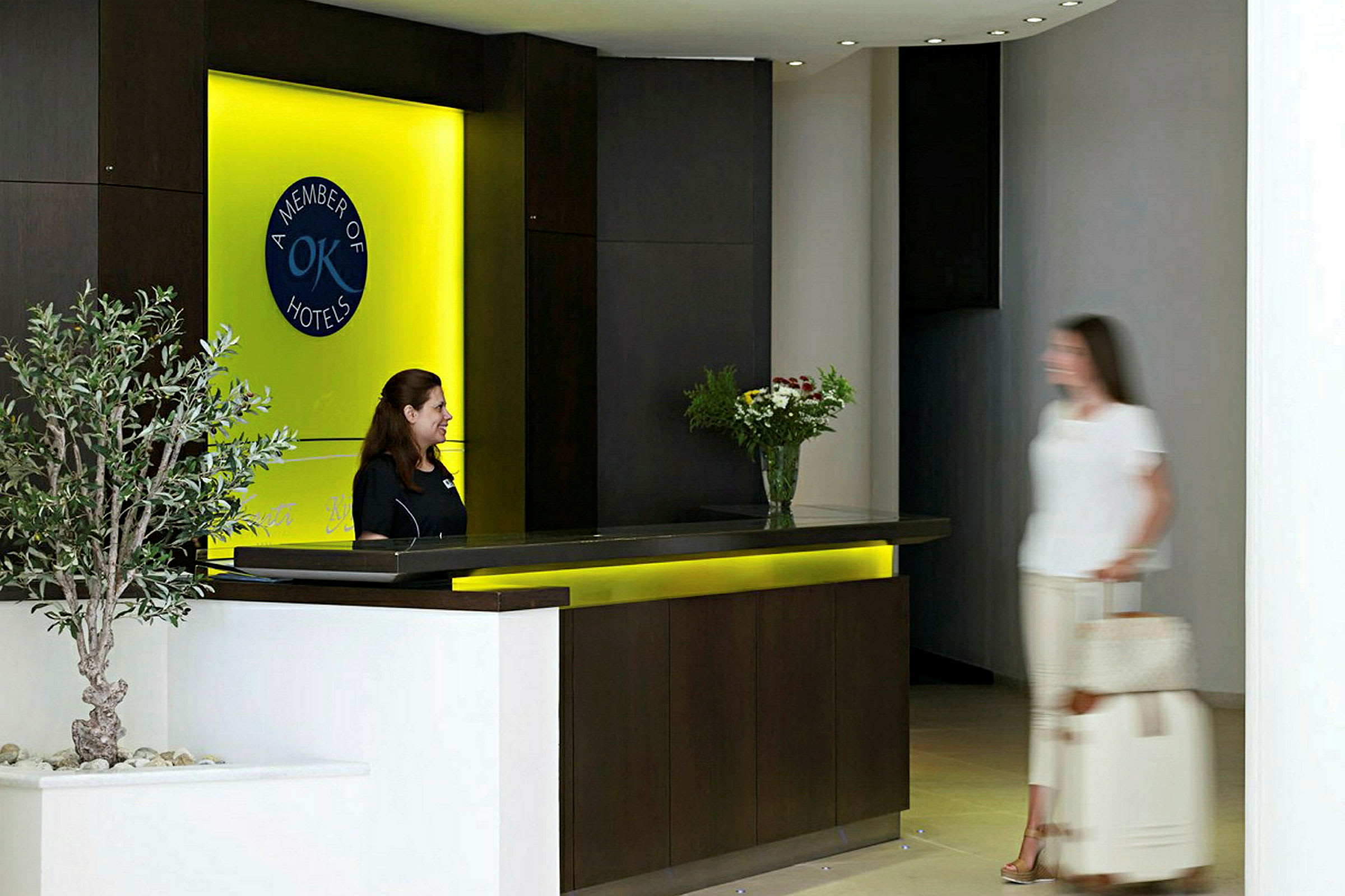 Receptionen på et hotel med en skranke og imødekommende personale. (AI-genereret tekst)