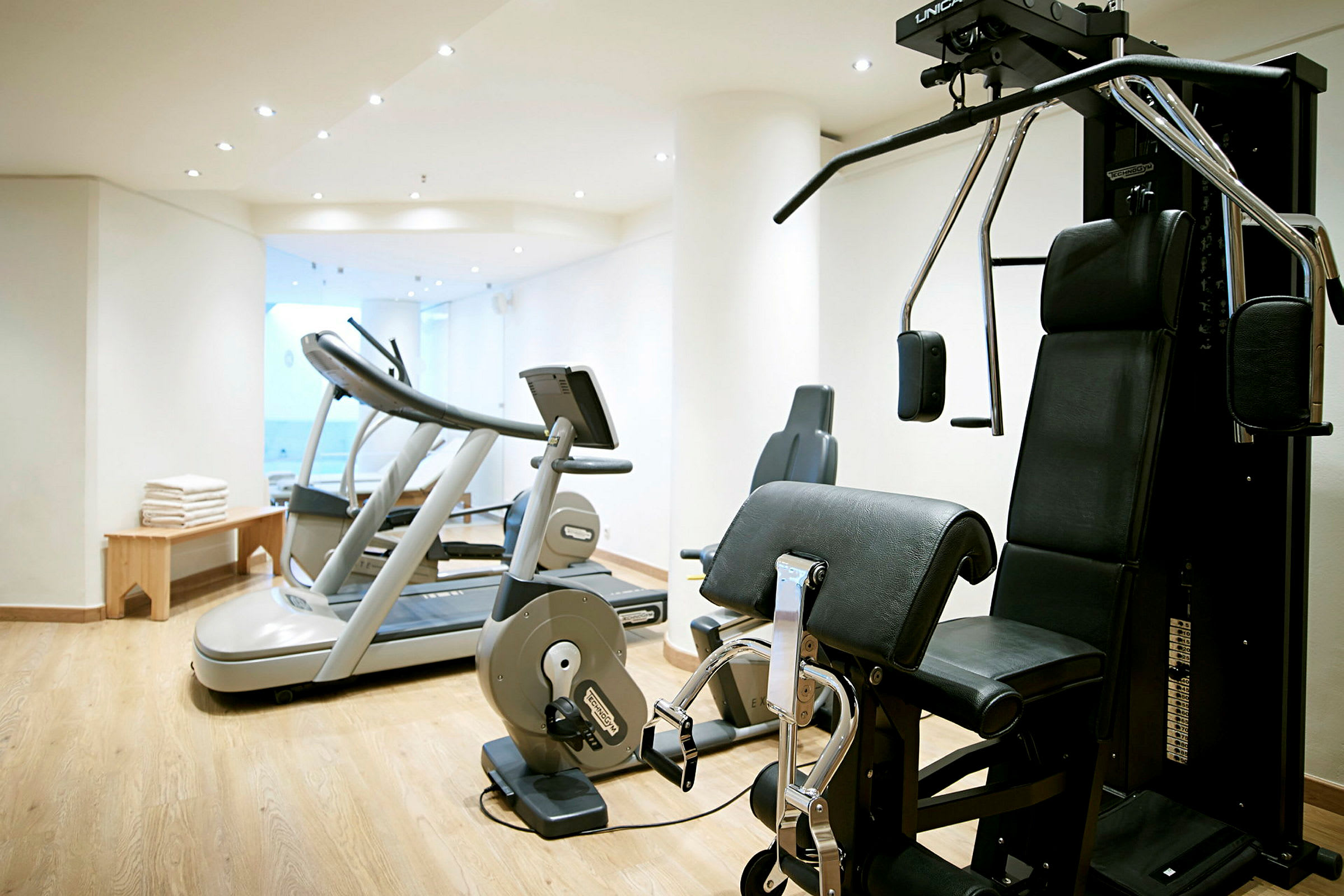 Et fitnesscenter med træningsmaskiner, herunder løbebånd og styrketræningsudstyr. (AI-genereret tekst)