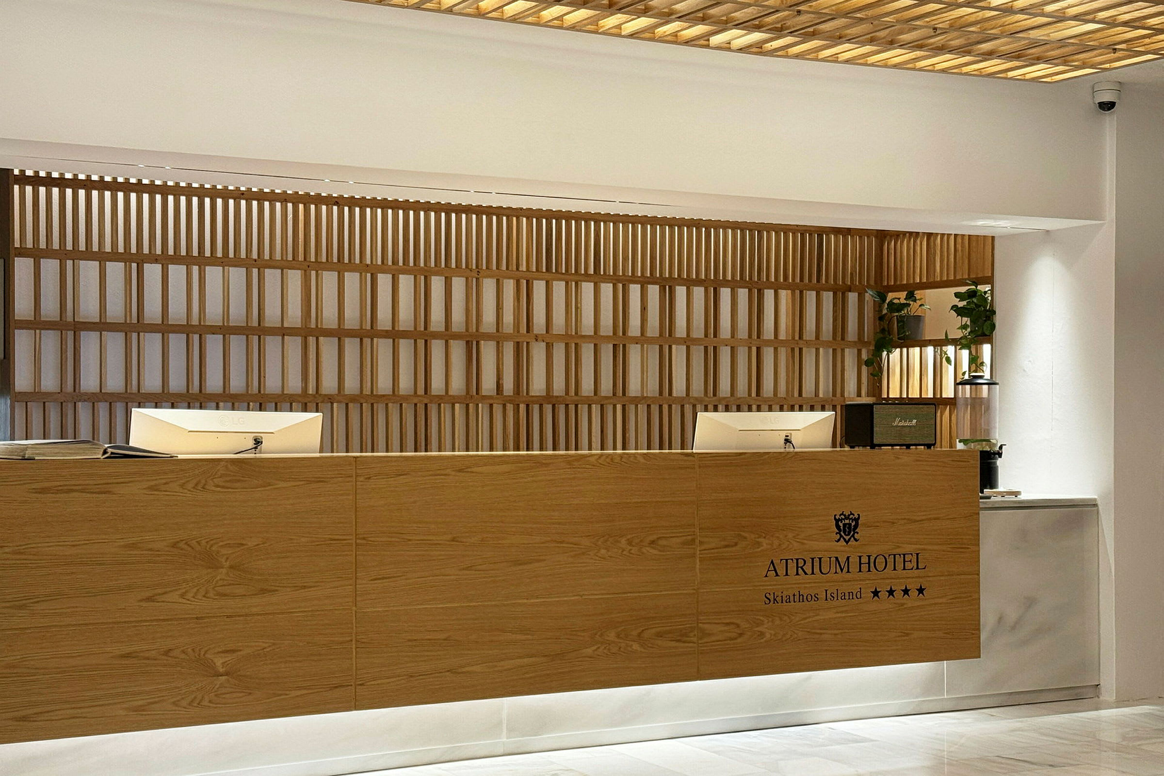 Hotellets reception med træpaneler og computerskærme. (AI-genereret tekst)