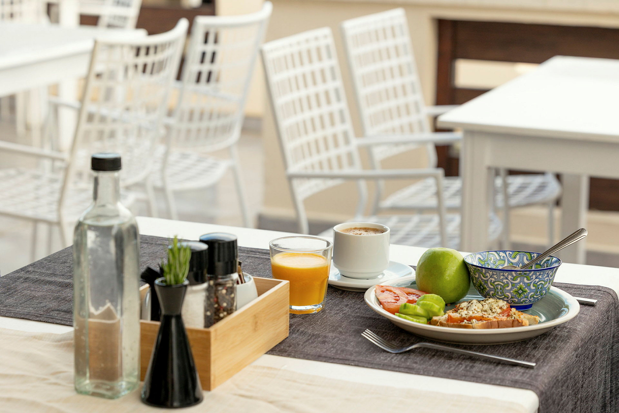 Et dækket bord med morgenmad: kaffe, juice, frugt og brød. (AI-genereret tekst)