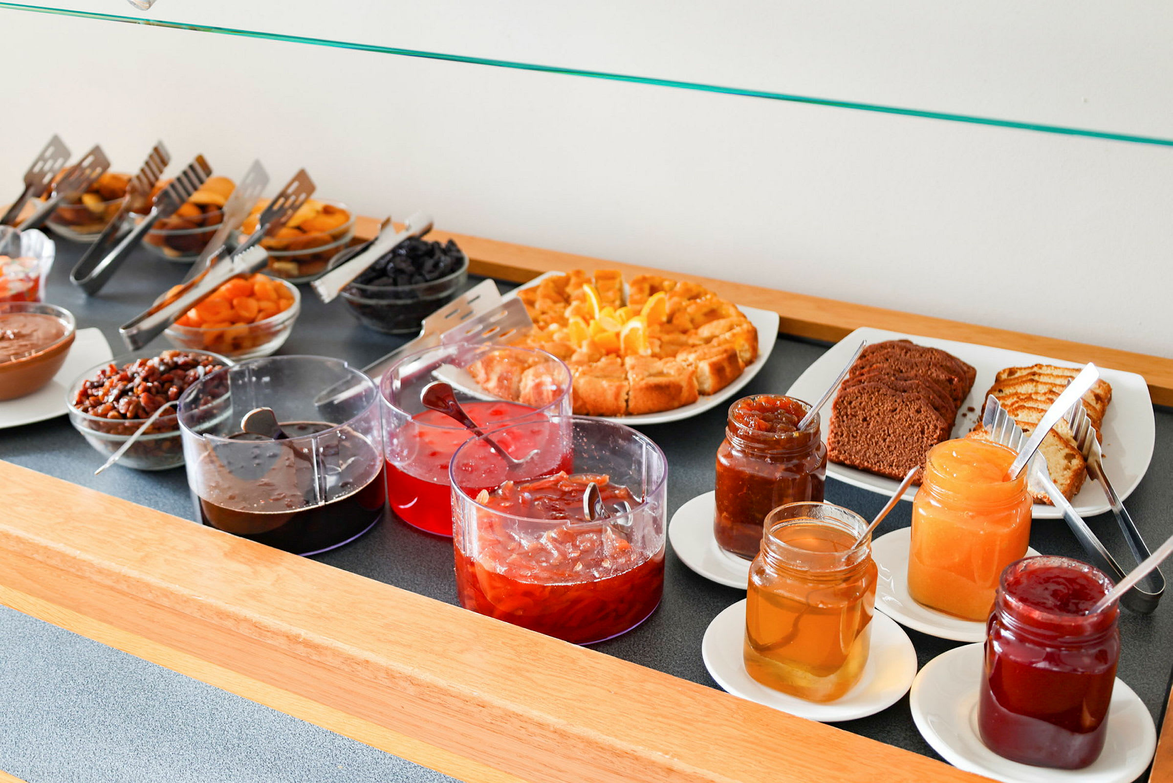 Buffet med forskellige syltetøj, bagværk og tørret frugt. (AI-genereret tekst)