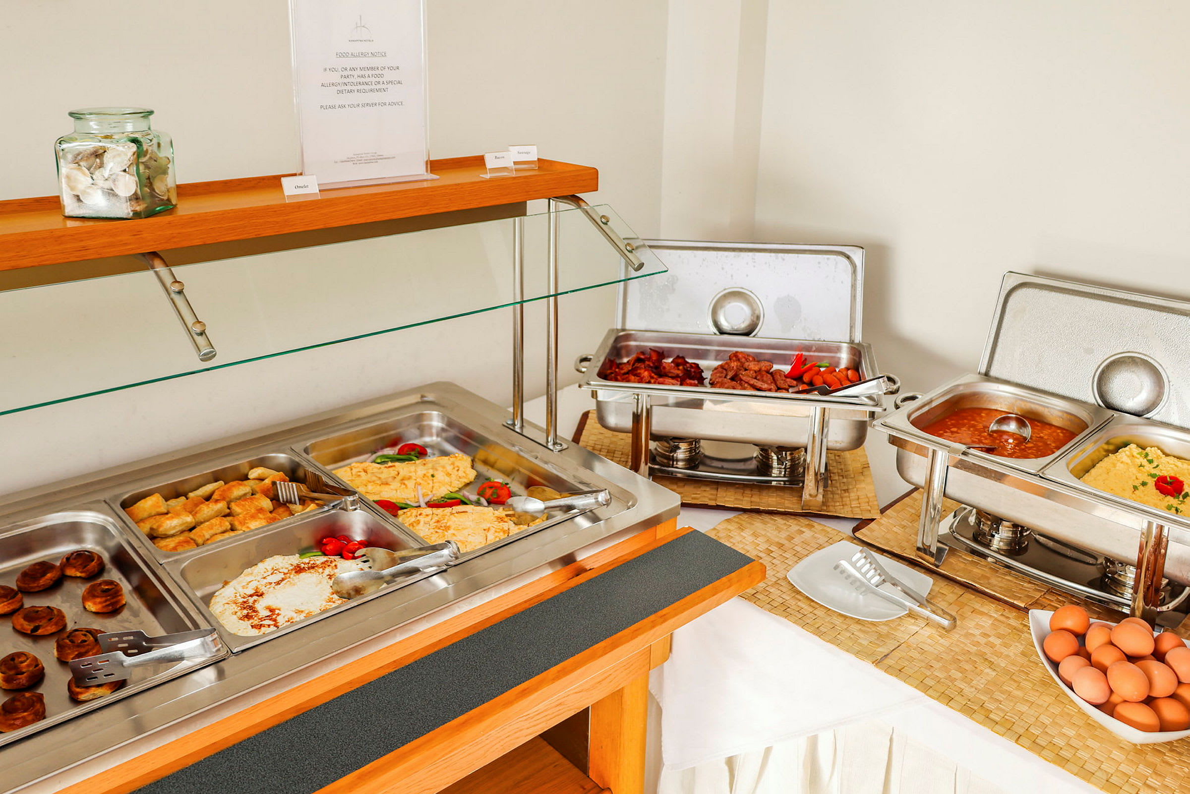 Buffet med varme retter og tilbehør. (AI-genereret tekst)