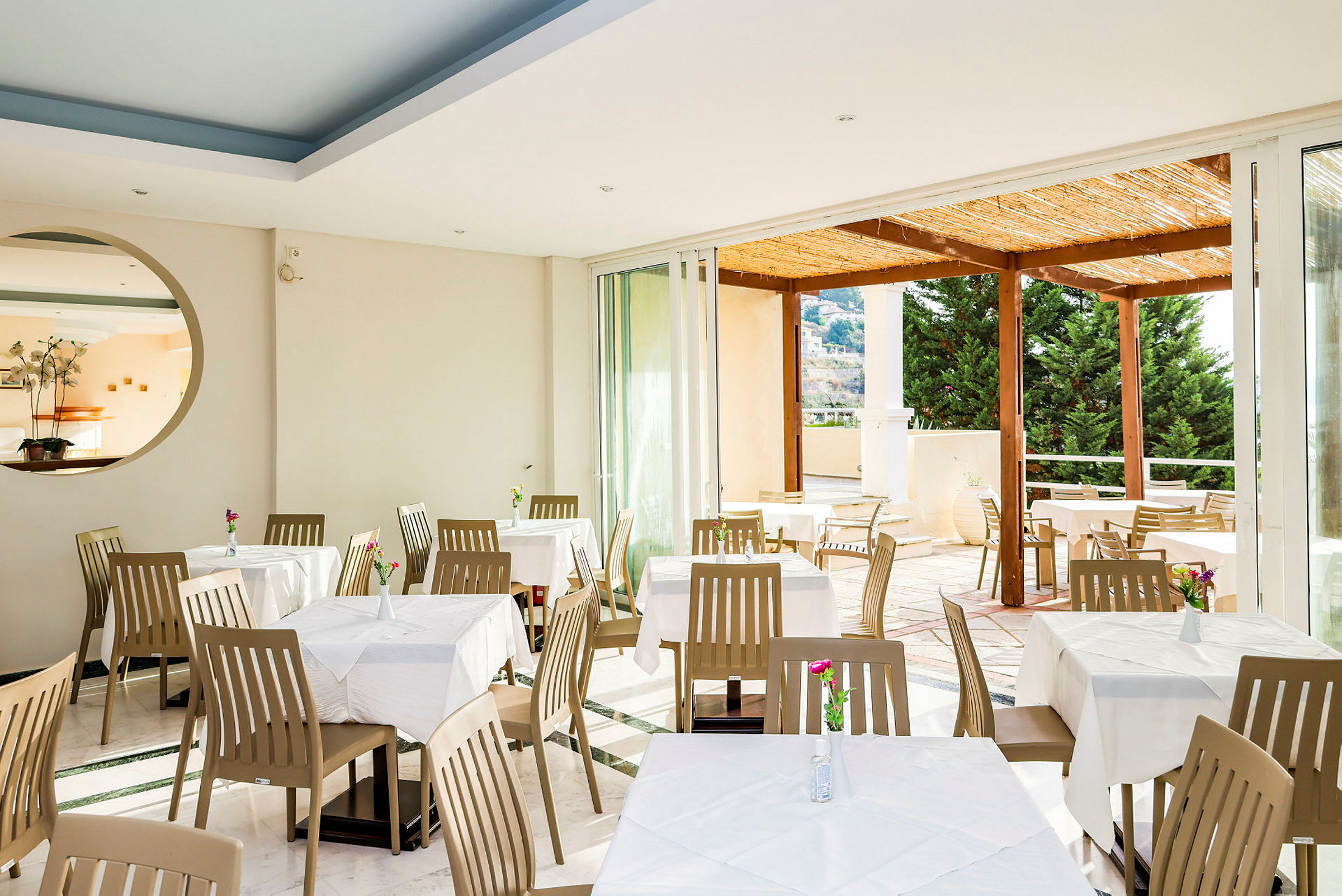 Restaurant med spiseborde og stole, udsigt til en terrasse. (AI-genereret tekst)