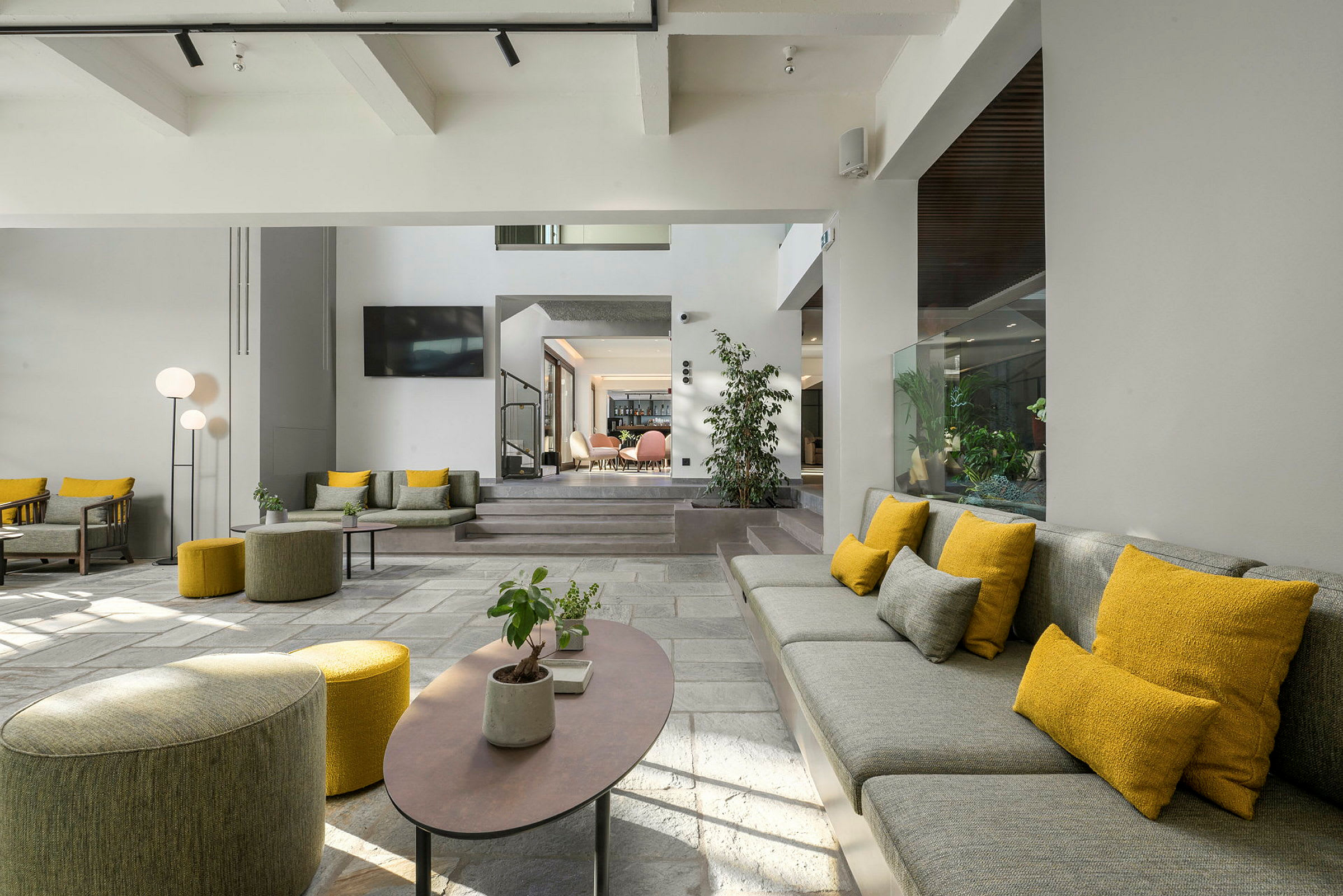 En moderne hotellobby med siddepladser i gråt og gult. (AI-genereret tekst)