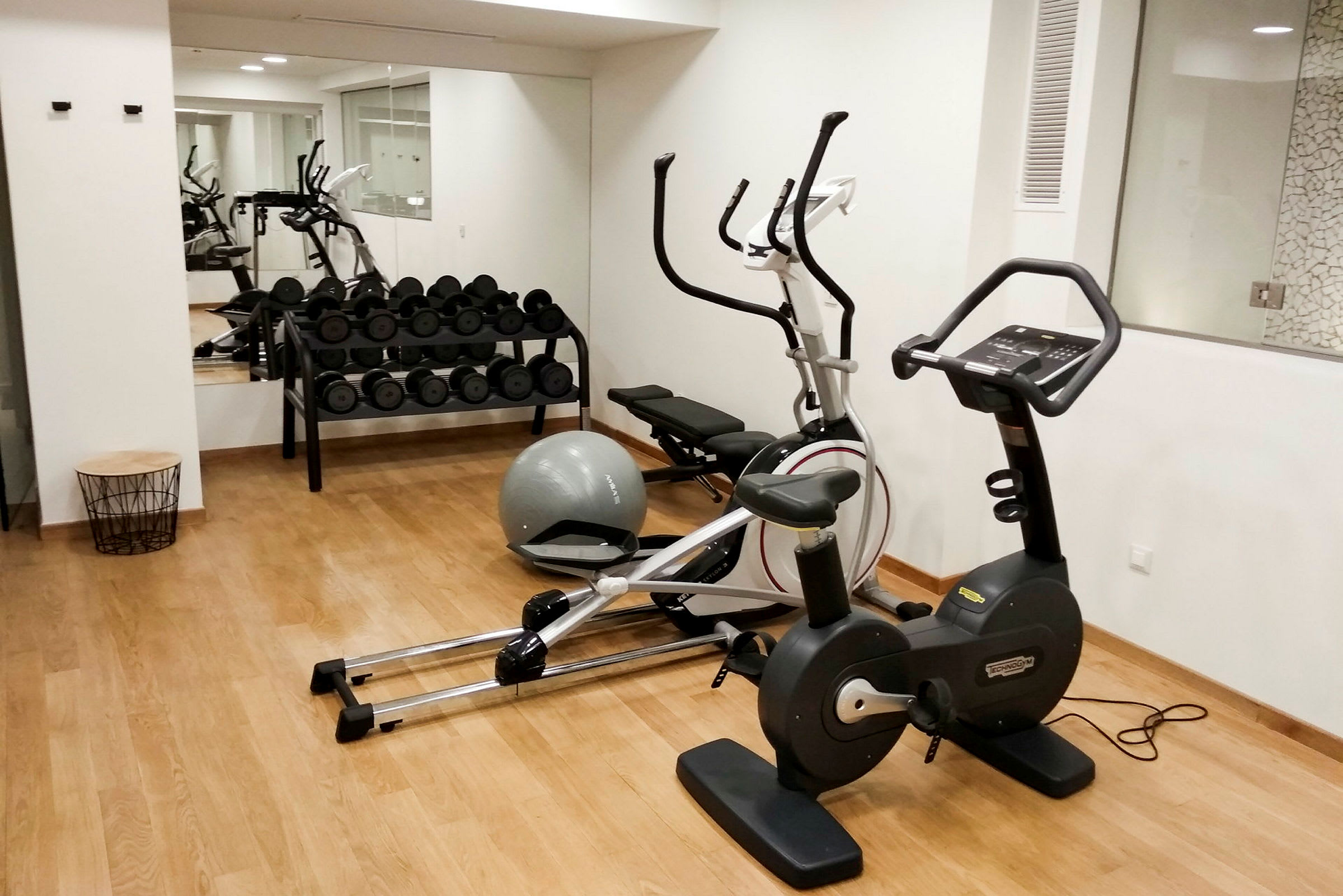 Et fitnessrum med træningsudstyr såsom motionscykel, vægte og balancebold. (AI-genereret tekst)