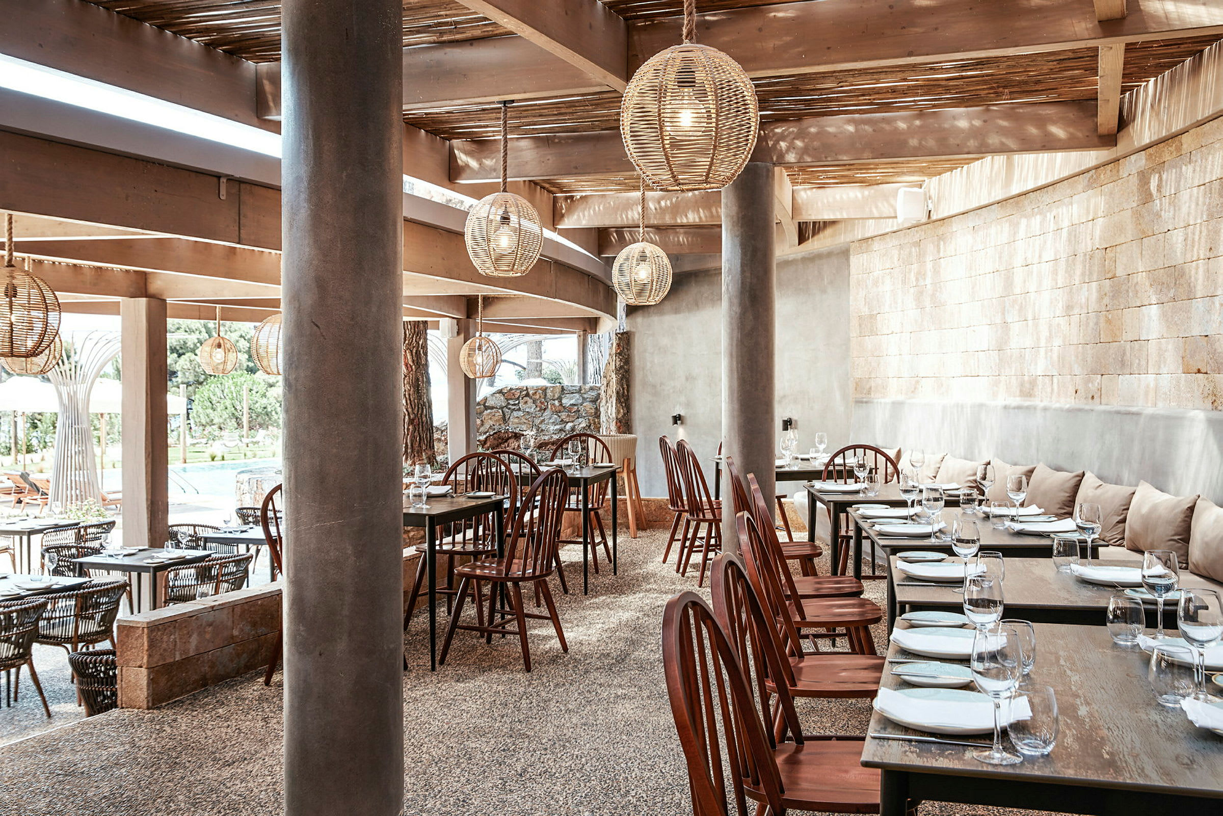 Restaurant med træborde, stole og hængende lamper. (AI-genereret tekst)