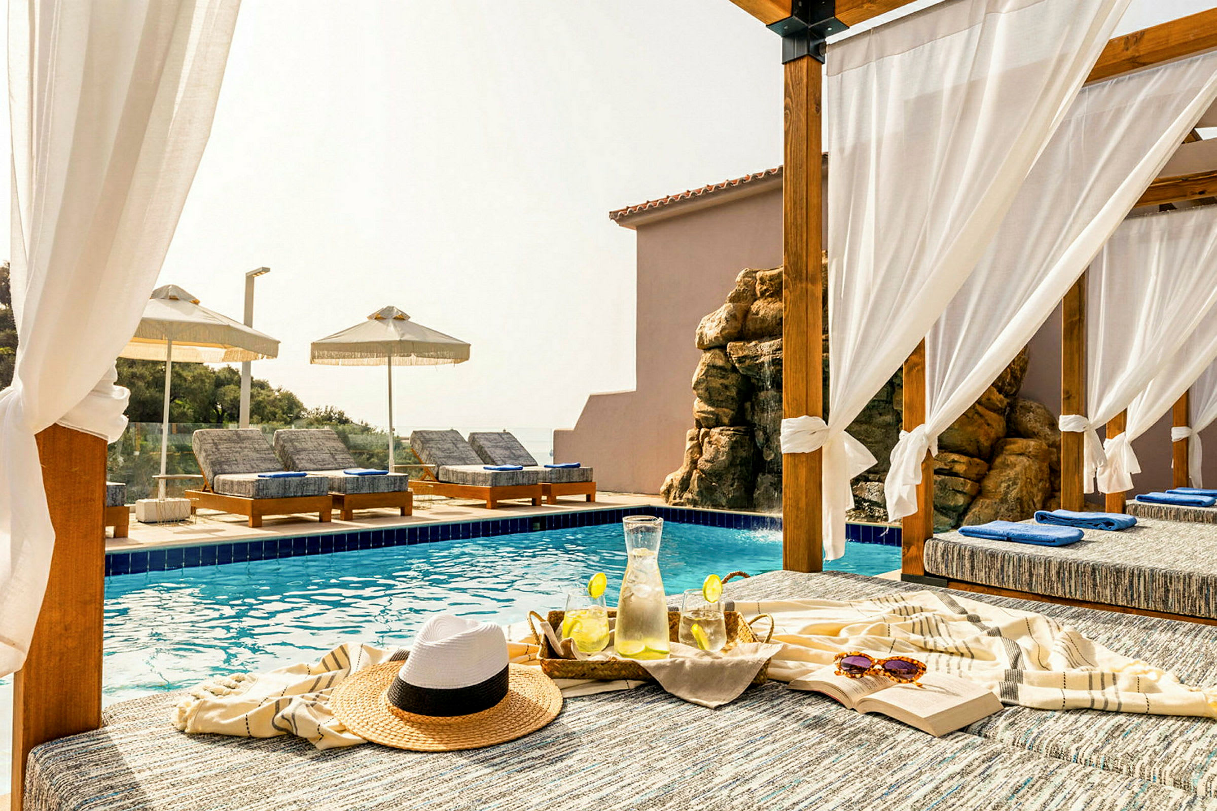 Privat pergola ved en pool med liggestole og serveret koldt citronvand. (AI-genereret tekst)