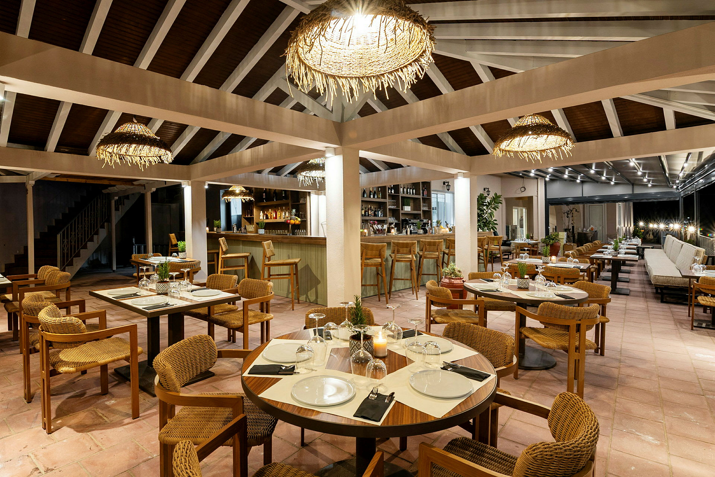Restaurant med opdækkede borde, stole og bar i baggrunden. (AI-genereret tekst)