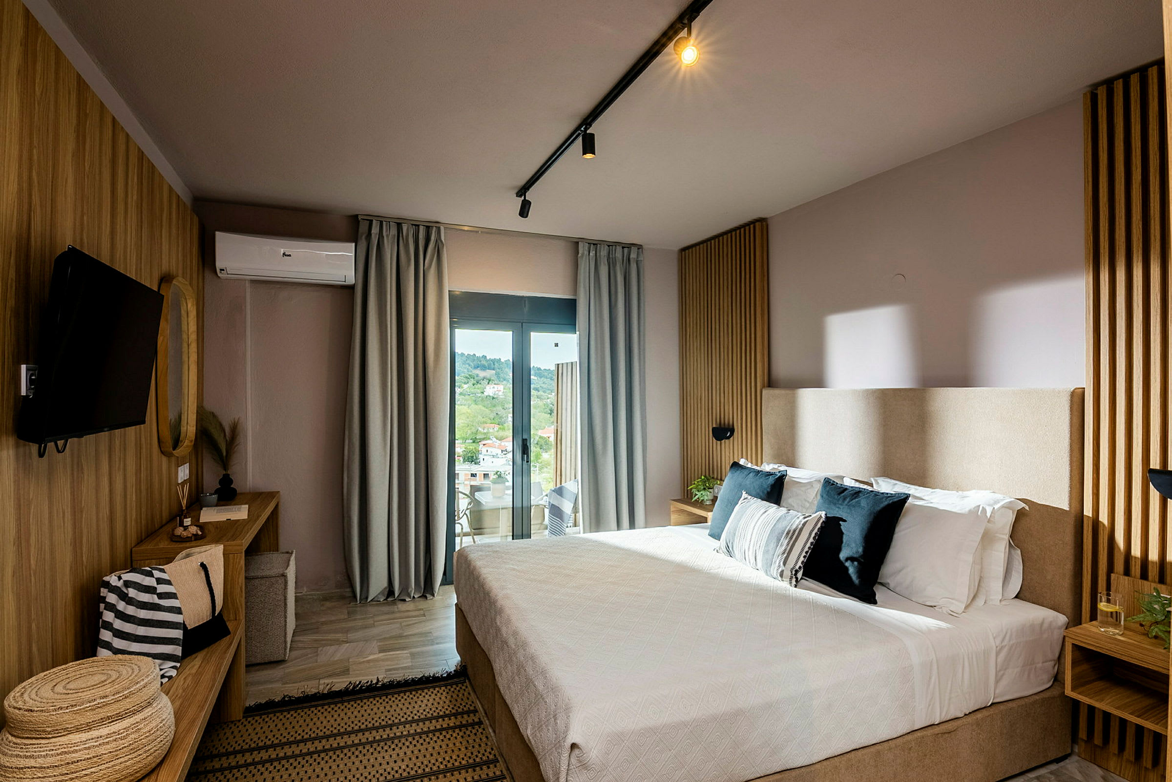 Et moderne hotelværelse med seng, skrivebord og stort vindue med udsigt. (AI-genereret tekst)