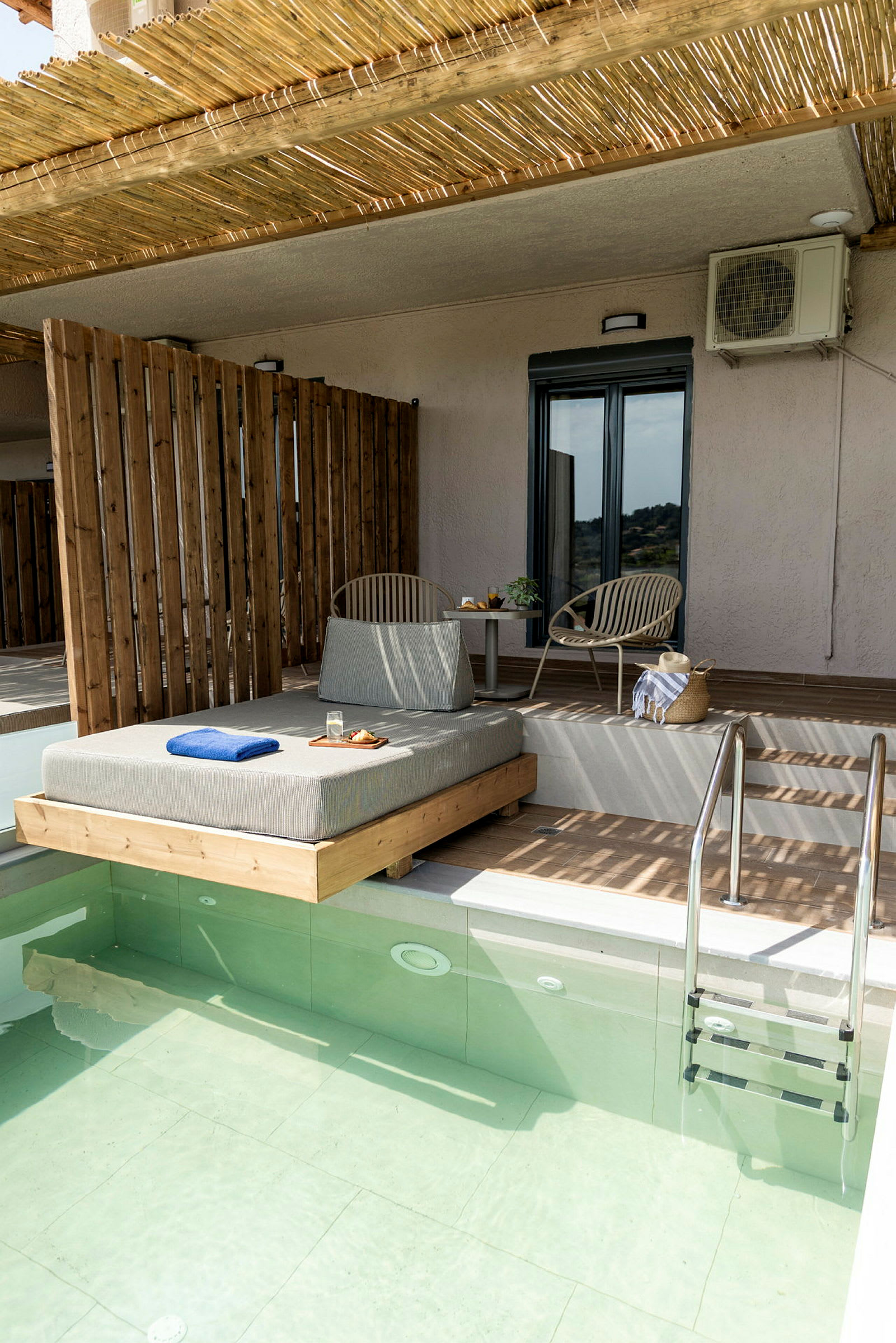 En terrasse med en privat pool, liggestol, bord og stole. (AI-genereret tekst)