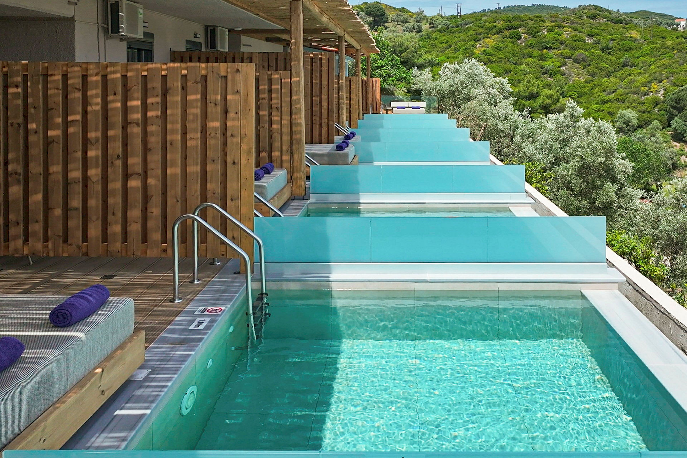 Private pools med solsenge og udsigt over frodigt landskab. (AI-genereret tekst)