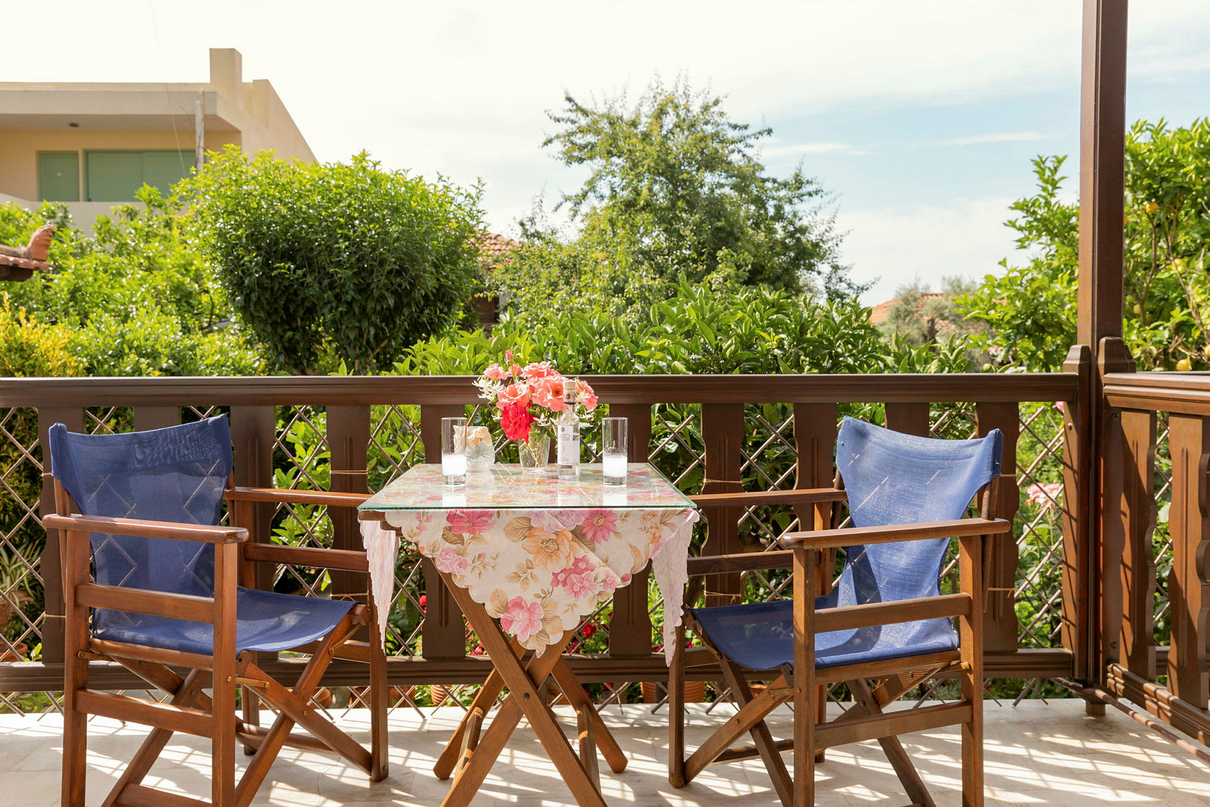 En terrasse med to stole og et bord med blomster. (AI-genereret tekst)