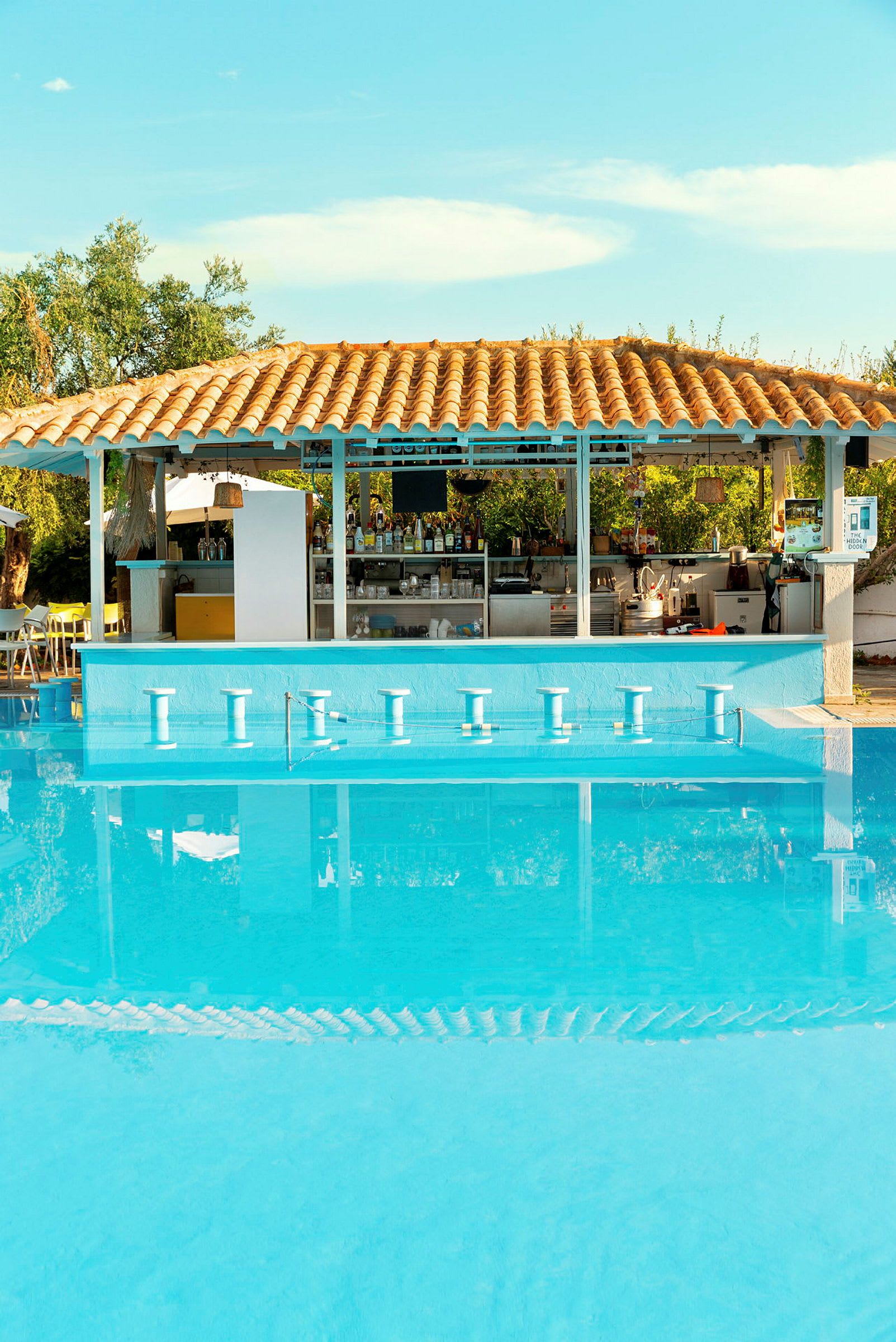 En udendørs pool med en bar under et tegltag. (AI-genereret tekst)