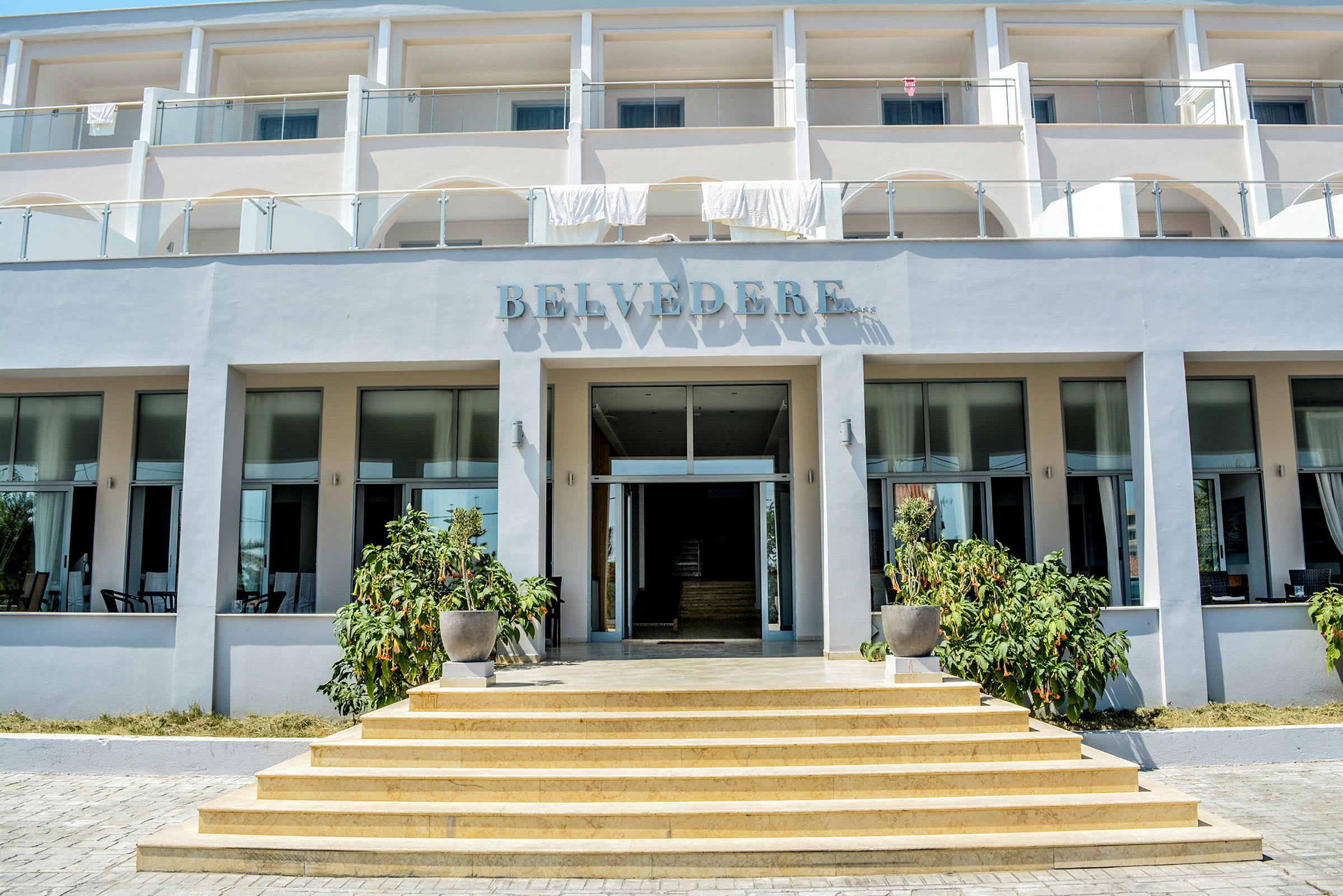 Hotelbygning med tre etager, navnet 'Belvedere' synligt over indgangen. (AI-genereret tekst)