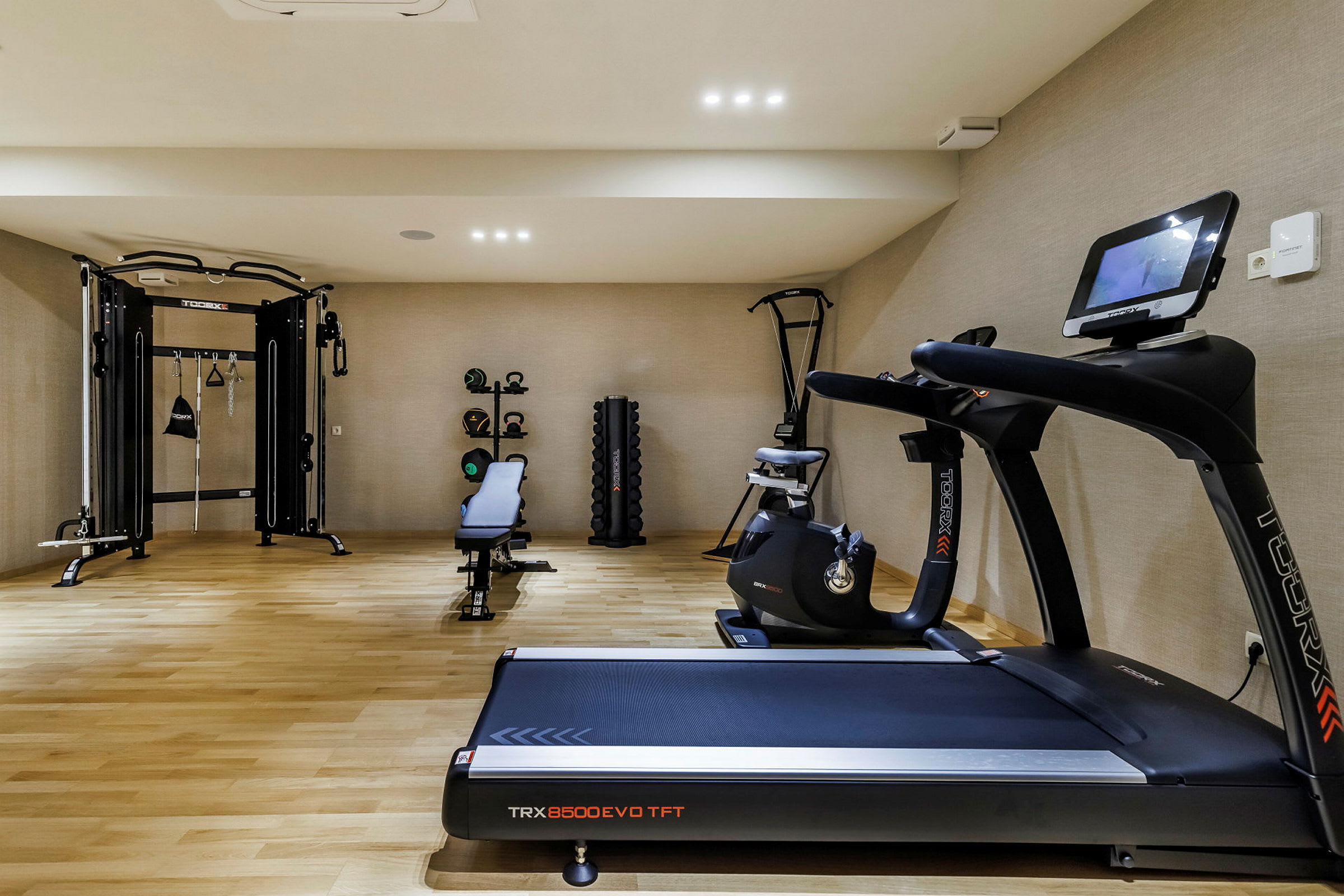 Billede af et fitnesscenter med træningsudstyr såsom løbebånd og styrketræningsmaskiner. (AI-genereret tekst)