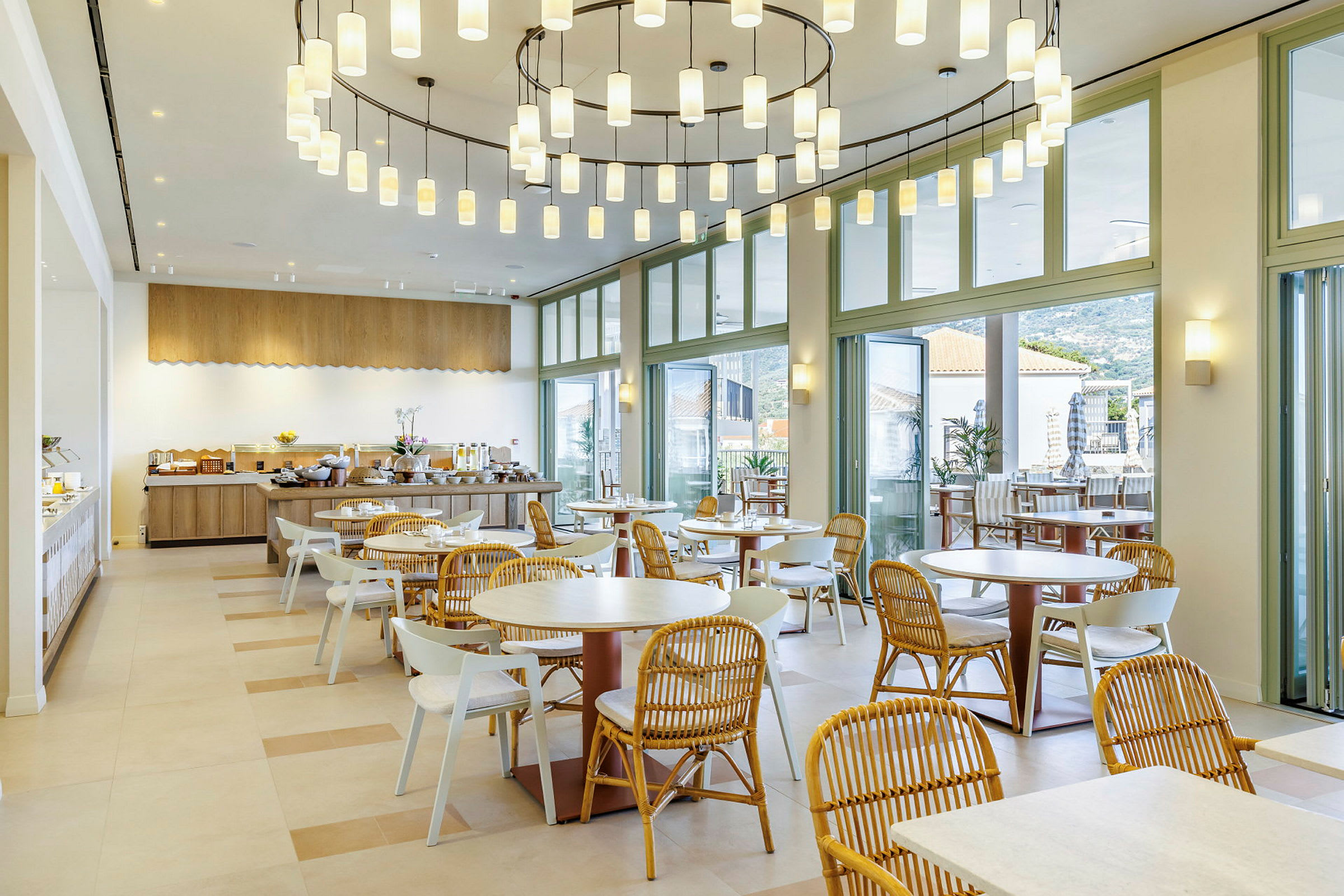 En moderne restaurant med store vinduer og runde borde og stole. (AI-genereret tekst)