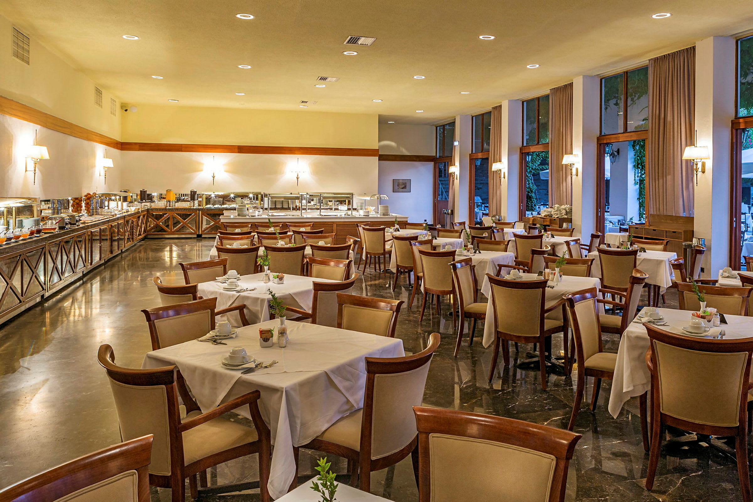 Billede af en restaurant med opdækkede borde og buffetområde. (AI-genereret tekst)