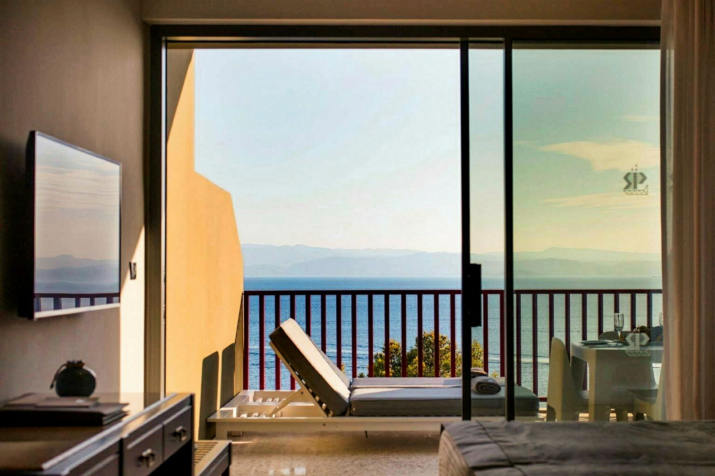 Udsigt fra hotelværelse med balkon mod havet. (AI-genereret tekst)