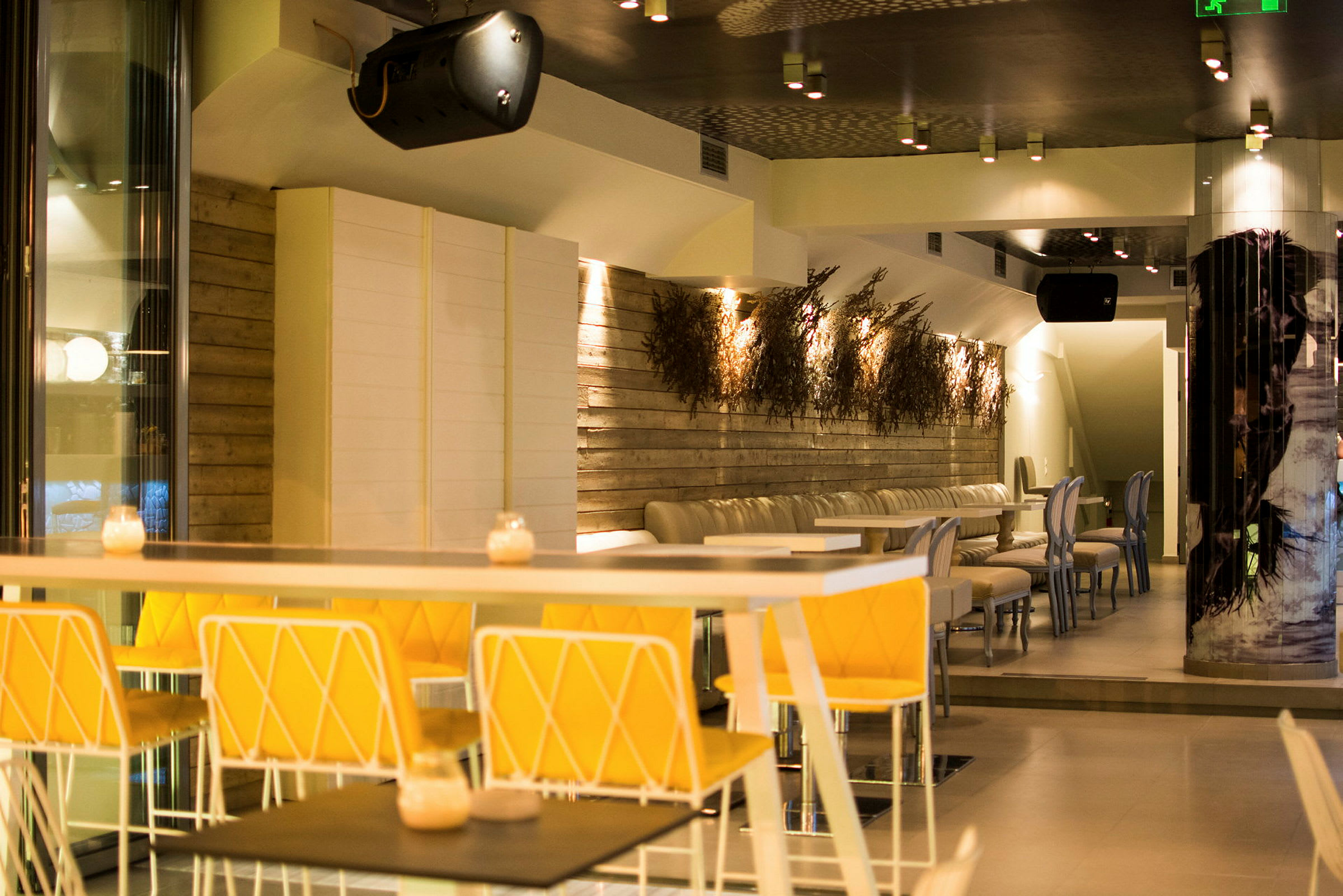 Interiør af en moderne restaurant med oplyste vægdekorationer og siddepladser. (AI-genereret tekst)