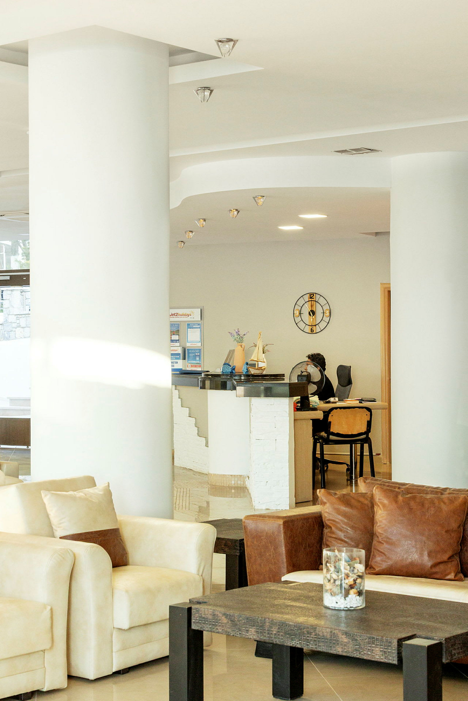 Hotellets reception med moderne indretning og komfortable sidemøbler. (AI-genereret tekst)