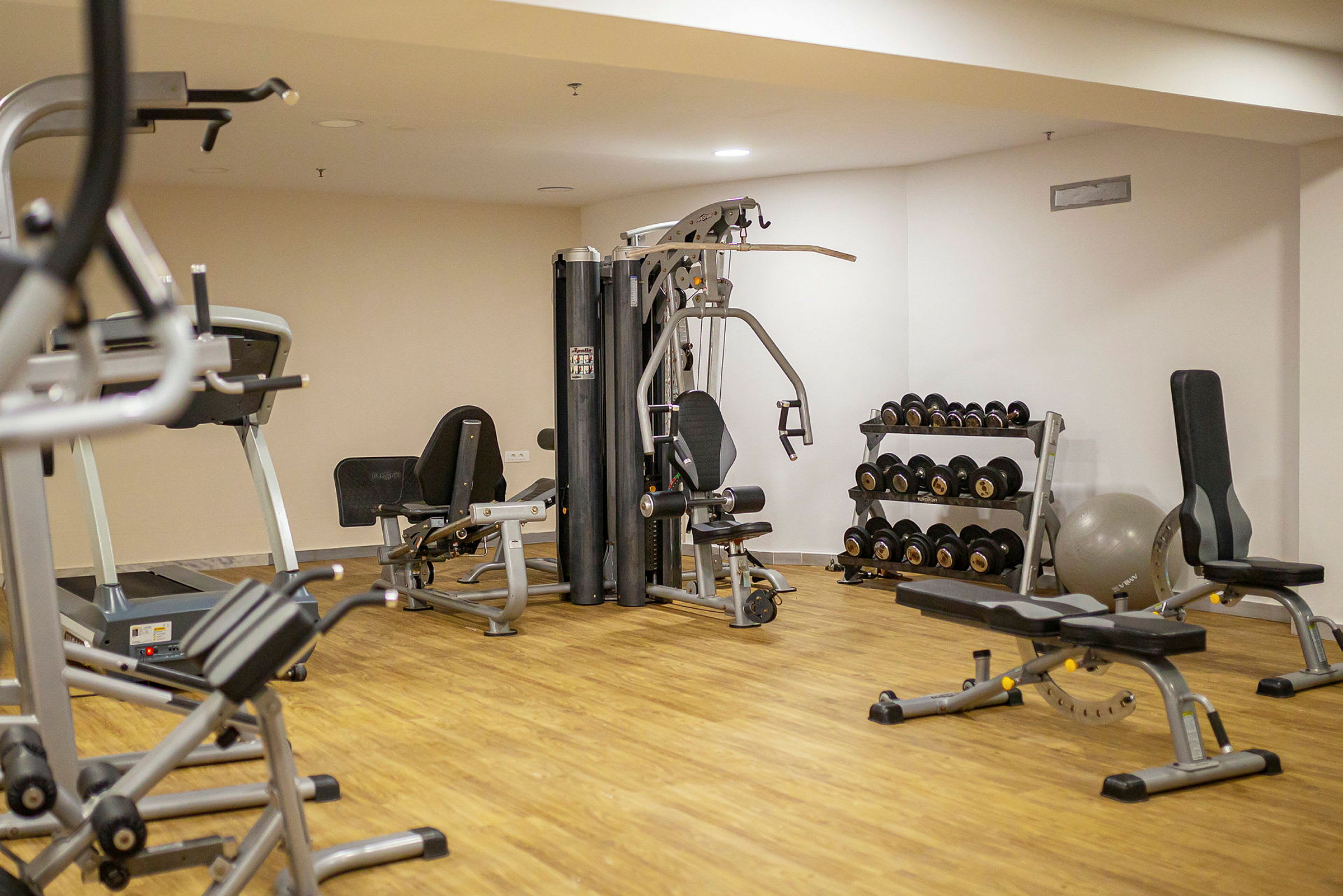 Et fitnesscenter med træningsmaskiner, håndvægte og bænke. (AI-genereret tekst)
