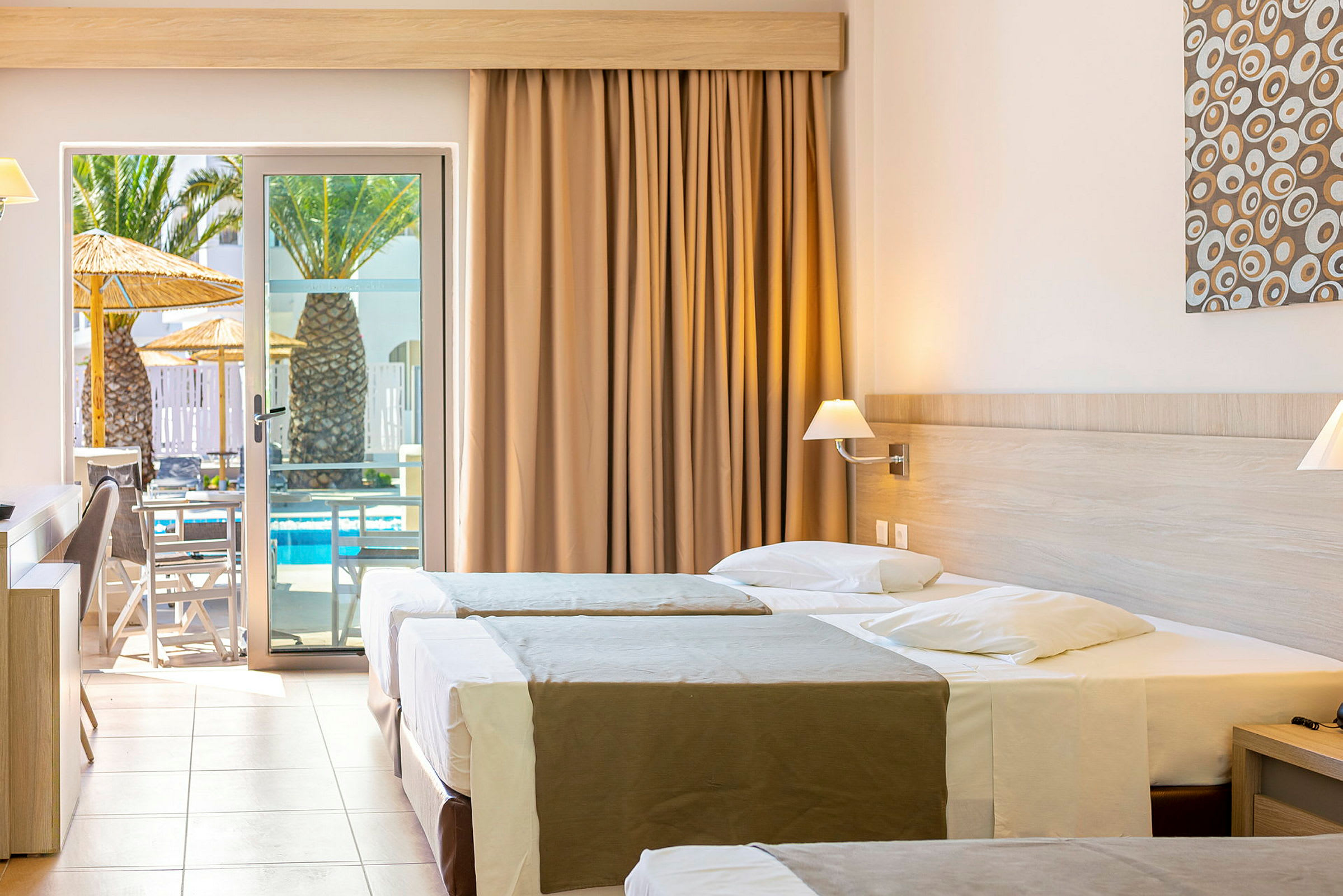 Hotelværelse med tre senge og udgang til terrasse med udsigt til poolen. (AI-genereret tekst)