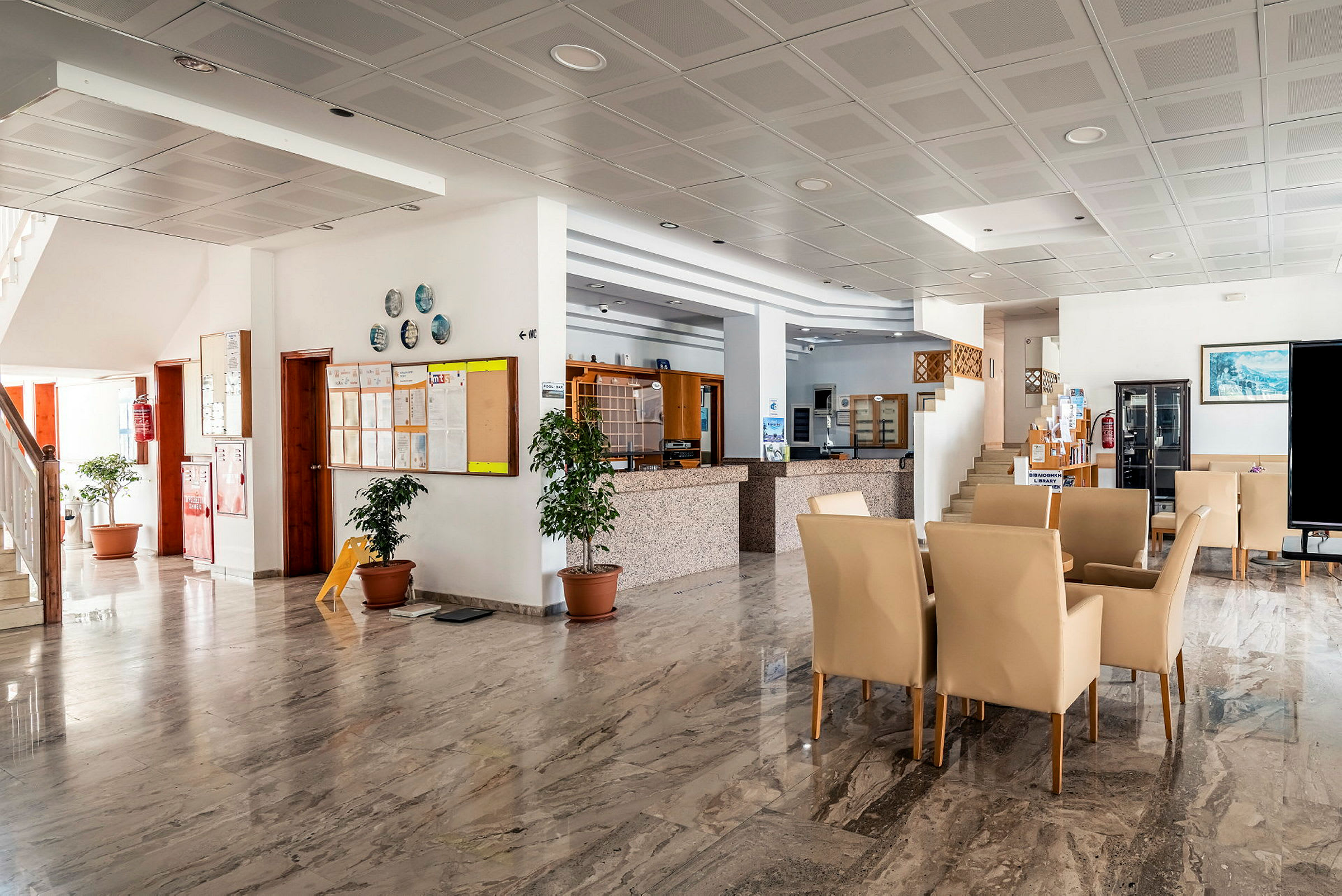 Interiør af et hotel. Lys lobby med marmorgulv og siddepladser. (AI-genereret tekst)