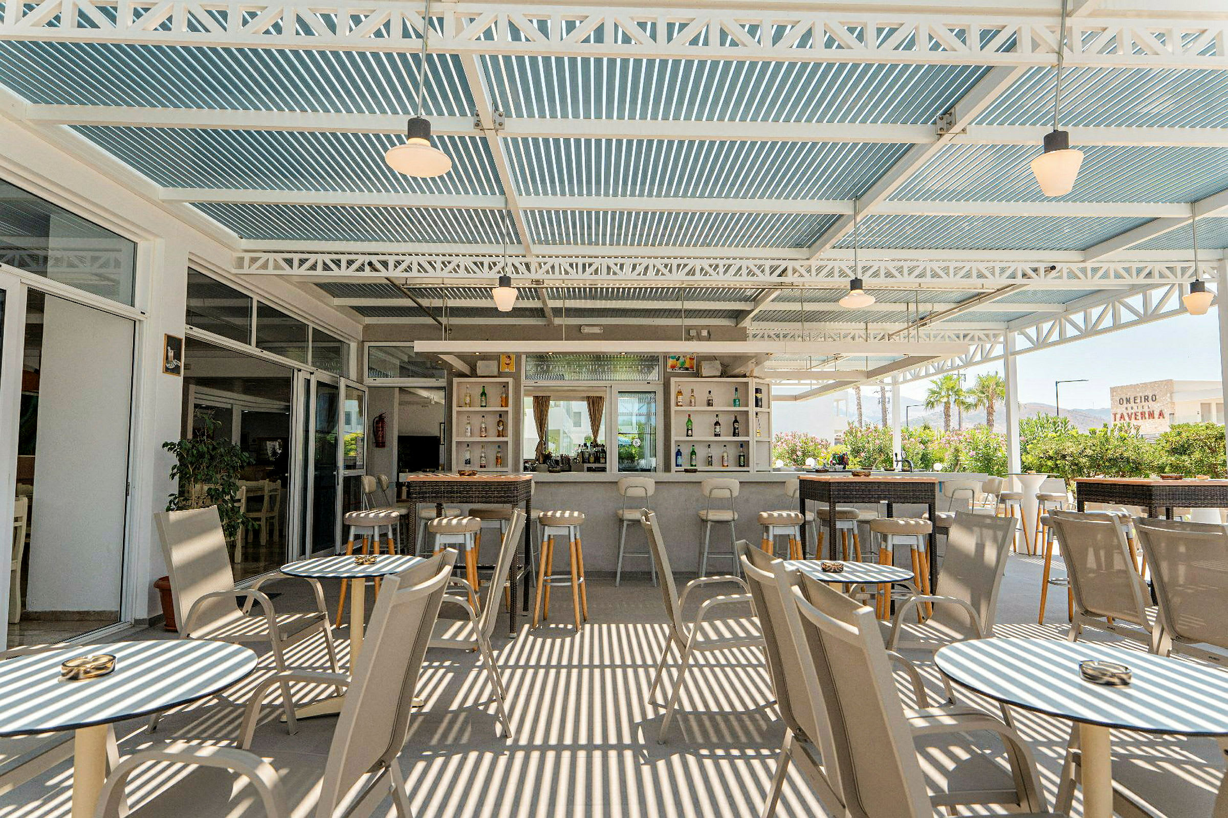 Terrasse med borde og stole samt en bar. (AI-genereret tekst)