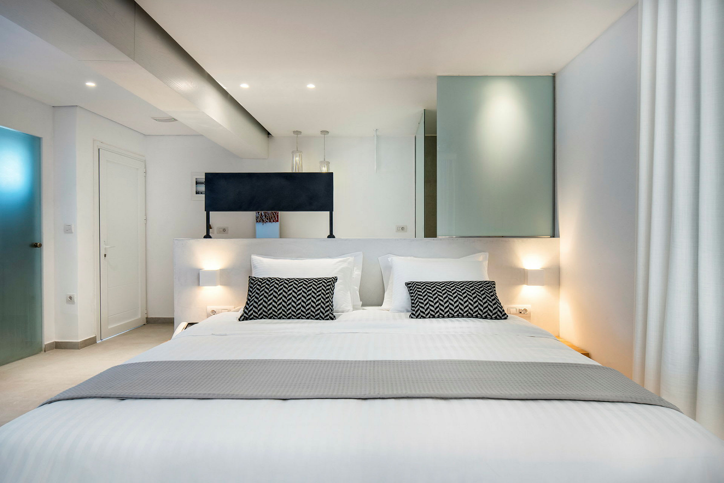 Et moderne hotelværelse med en stor dobbeltseng og stilfulde indretningsdetaljer. (AI-genereret tekst)