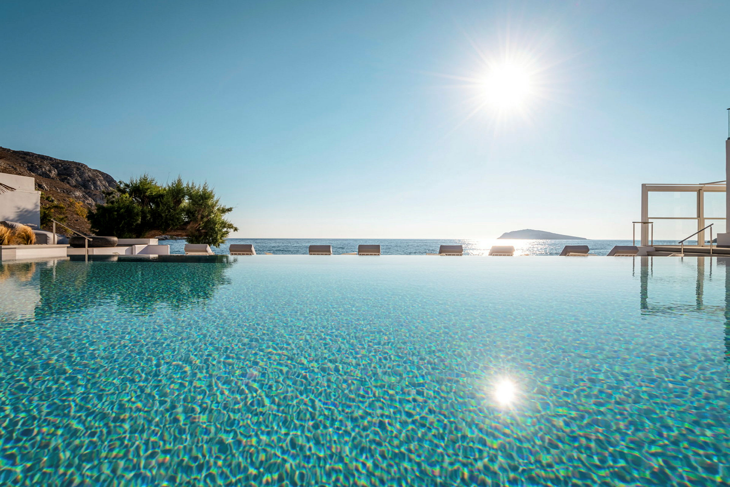 En infinitypool med udsigt over havet under en klar sol. (AI-genereret tekst)