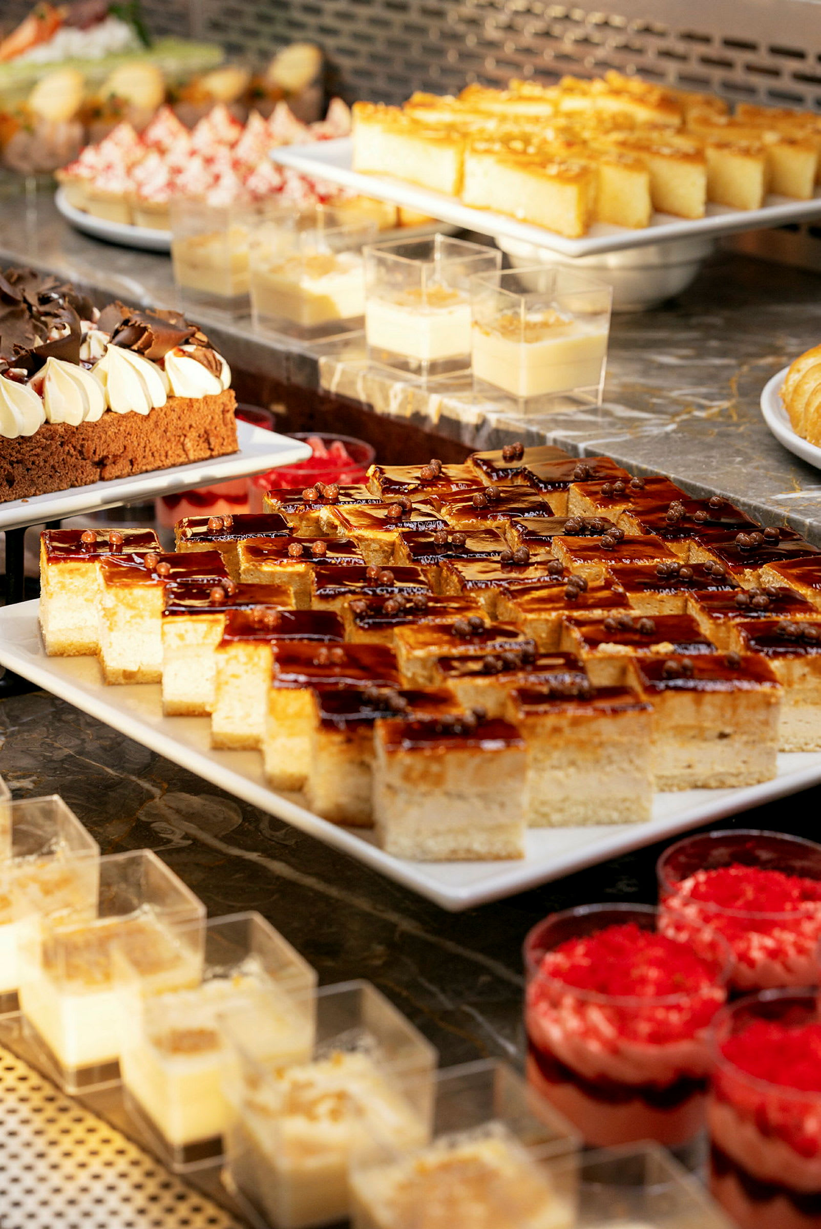 Et udvalg af desserter arrangeret på et buffetbord. (AI-genereret tekst)
