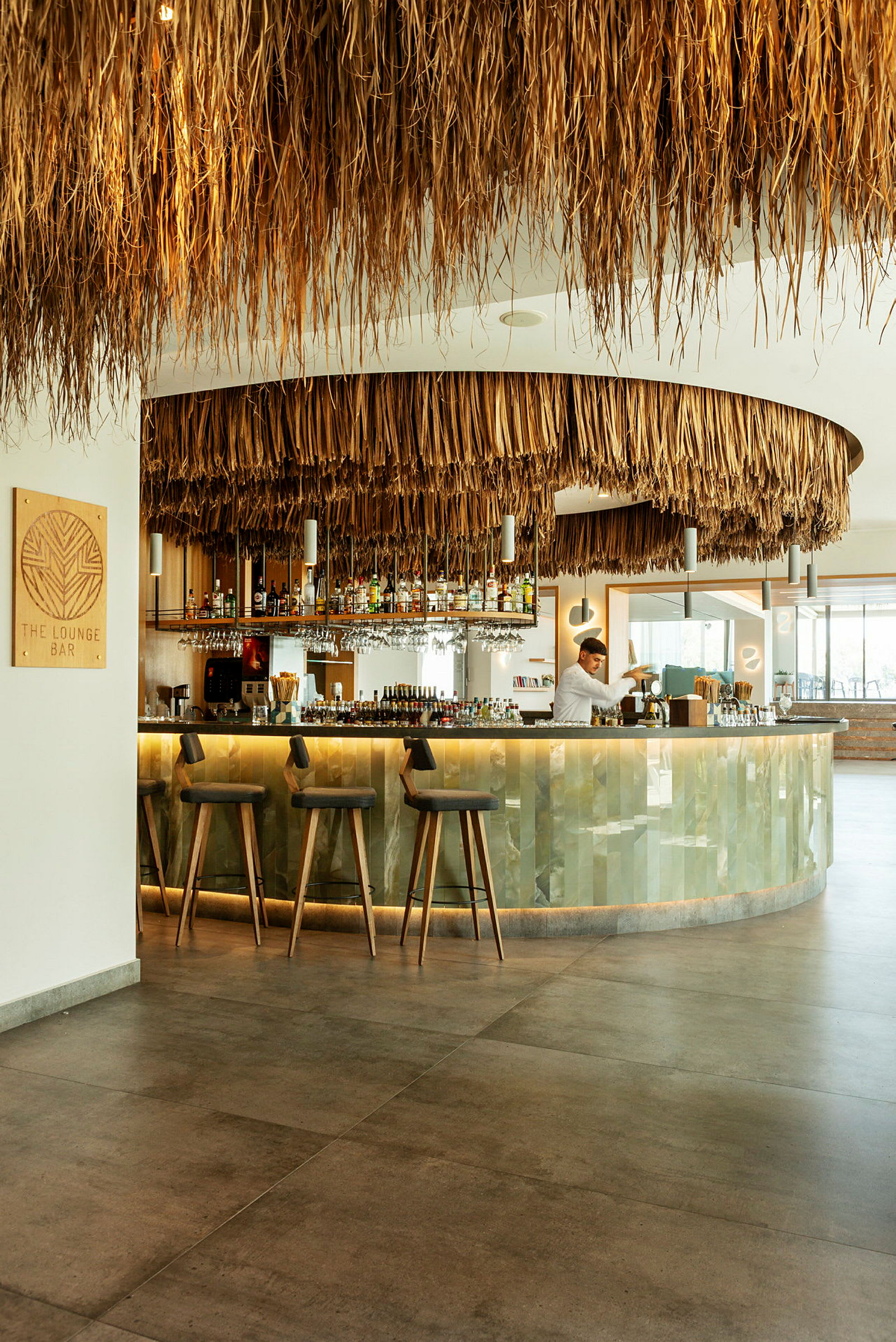 En moderne loungebar med et loft dekoreret med naturlige materialer og en veludstyret bardisk. (AI-genereret tekst)