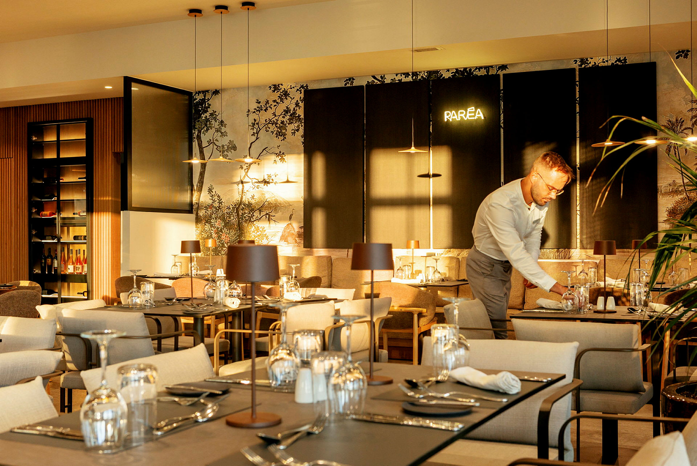 Restaurant med borde dækket til gæster og detaljeret interiørdesign. (AI-genereret tekst)