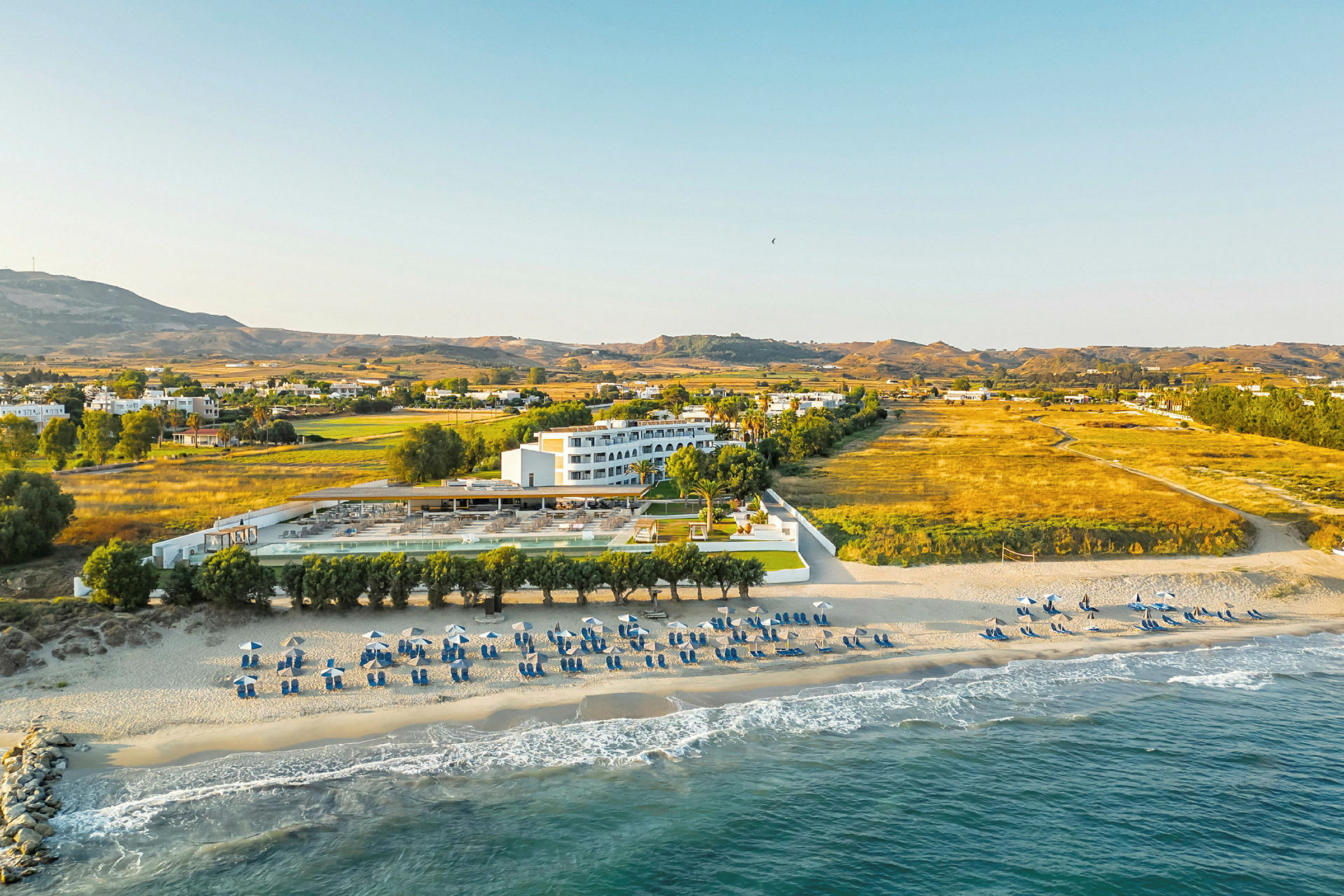 Strand og hotel med omkringliggende landskab. (AI-genereret tekst)