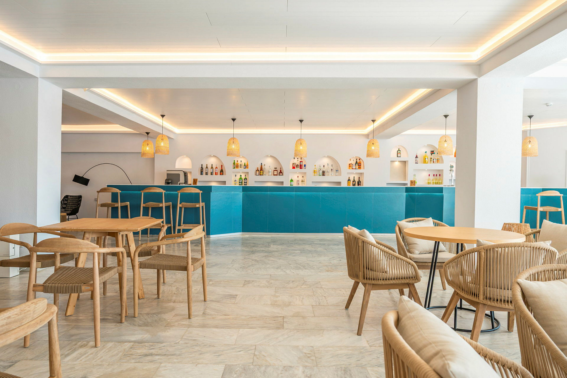 Billede af en lys og moderne bar med blå disk, designstole i træ og belysningsarmaturer. (AI-genereret tekst)