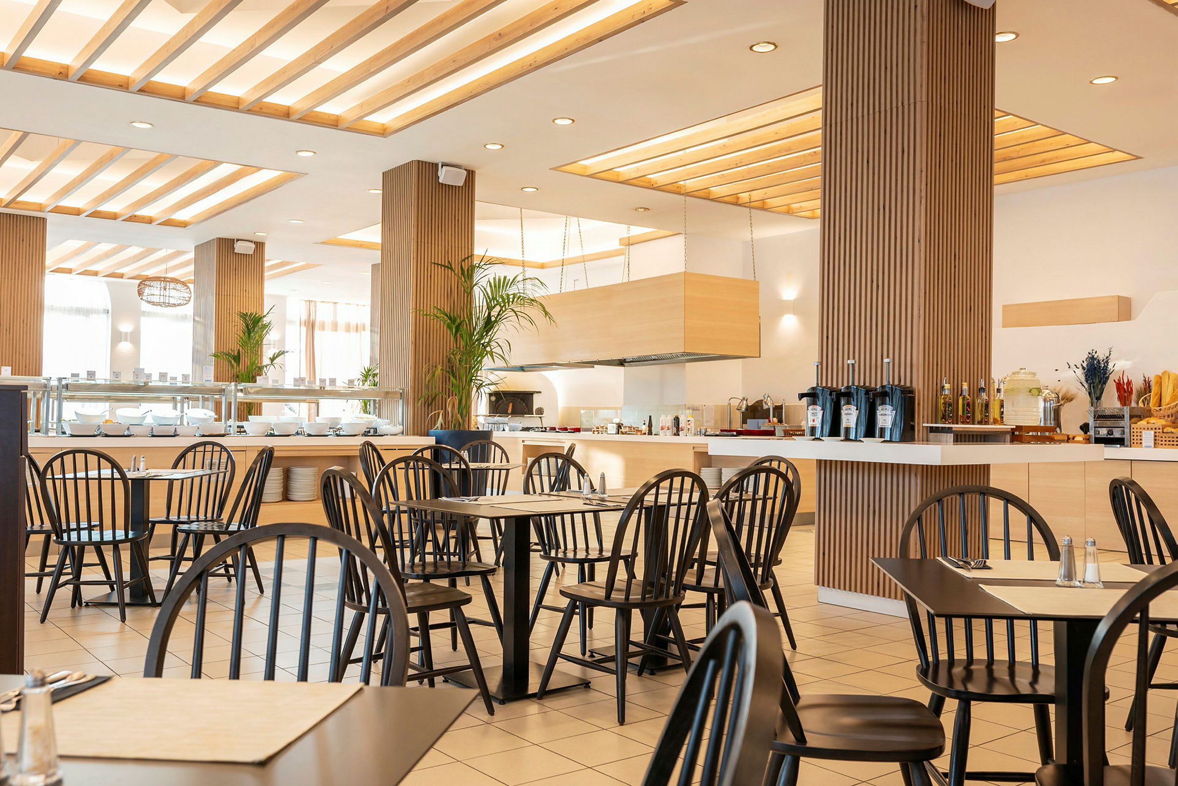En moderne restaurant med sorte stole og lyst interiør. (AI-genereret tekst)
