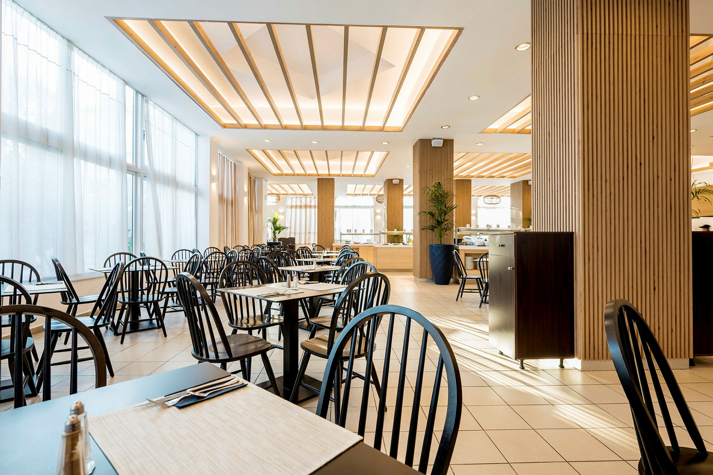 Restaurant med borde, stole og moderne indretning. (AI-genereret tekst)
