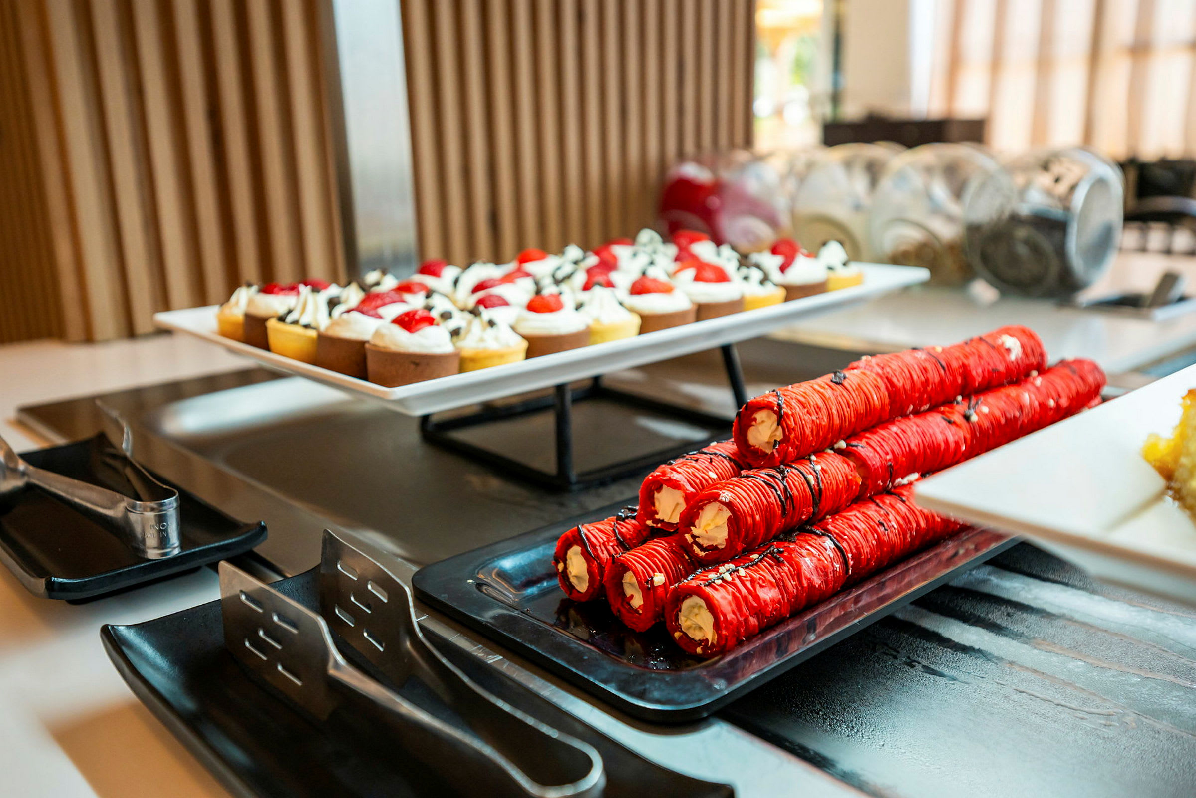 Et dessertbord med en tallerken små bagværk og ruller fyldt med creme. (AI-genereret tekst)