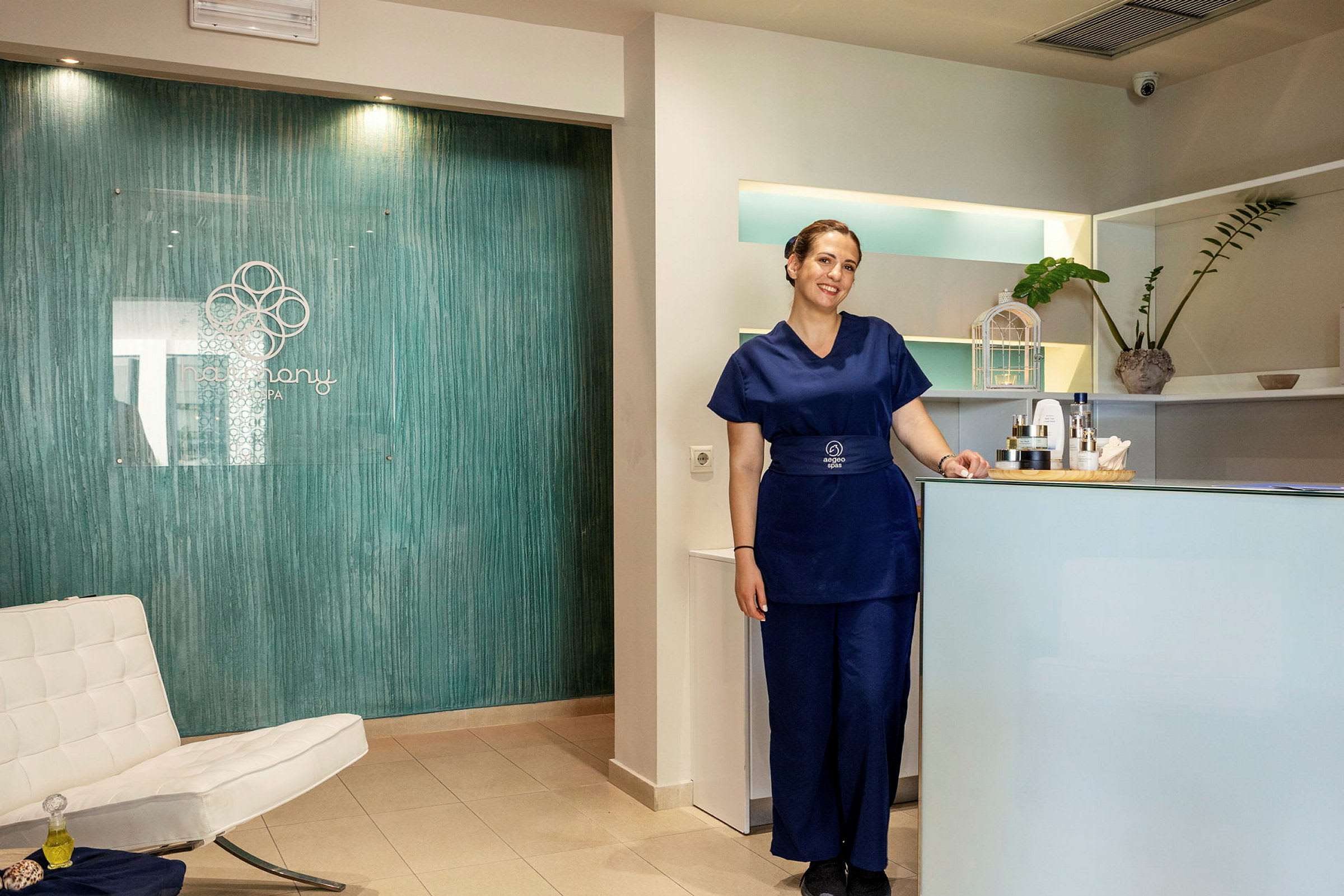 Receptionen i en spa med en hvid stol, et blåt bord og en informationsskranke. (AI-genereret tekst)