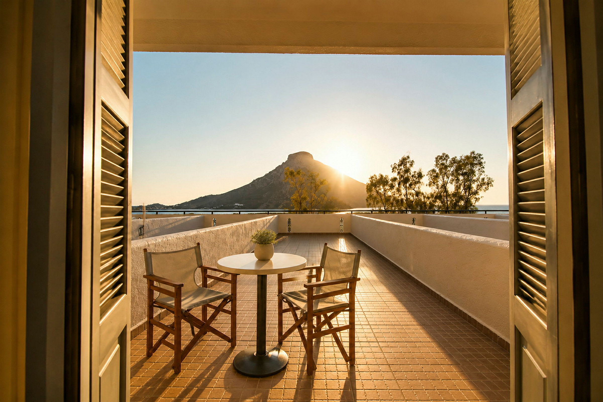 En terrasse med to stole og et bord, med udsigt til et bjerg ved solnedgang. (AI-genereret tekst)