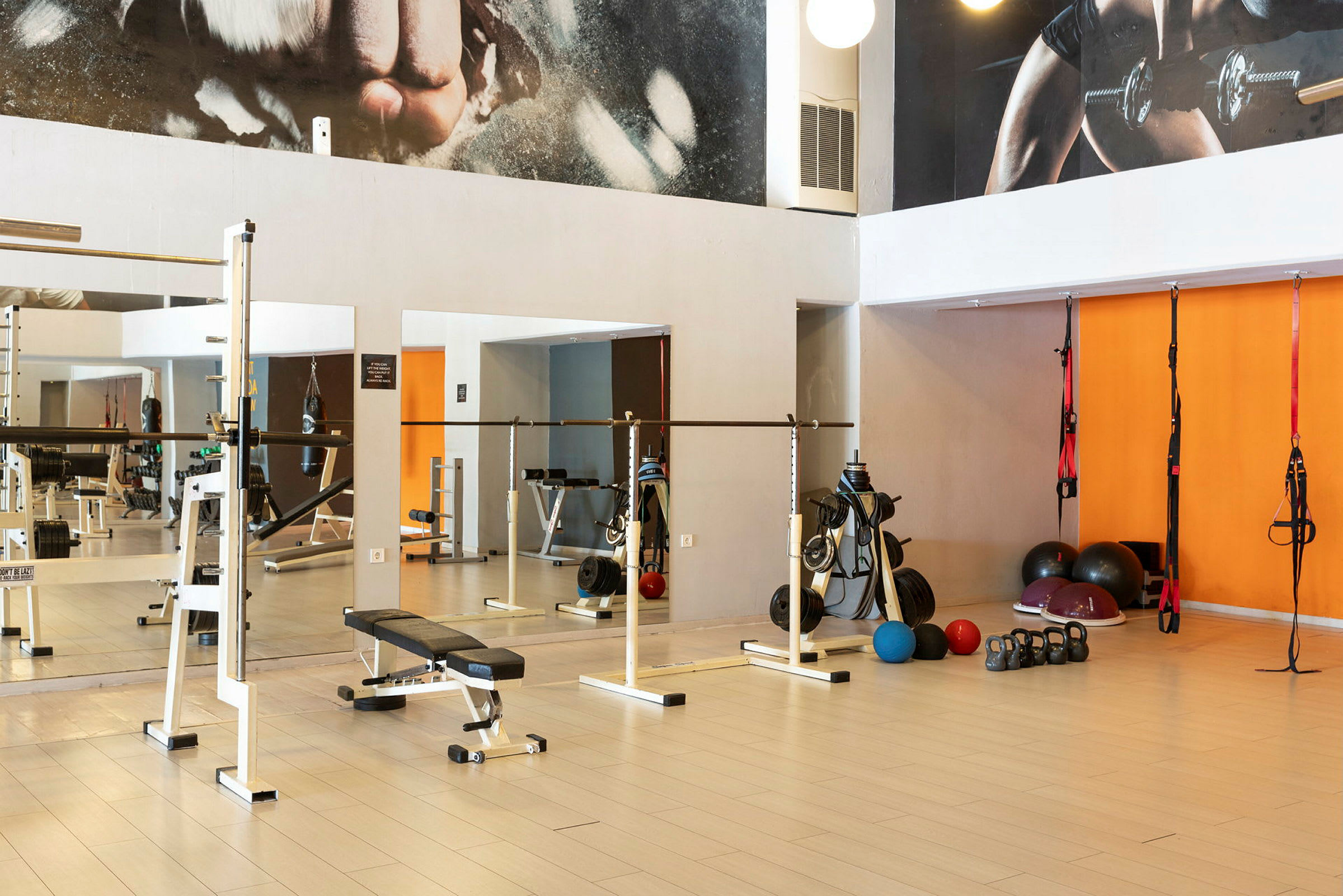 Et fitnesscenter med træningsudstyr såsom håndvægte, bænke og kettlebells. (AI-genereret tekst)