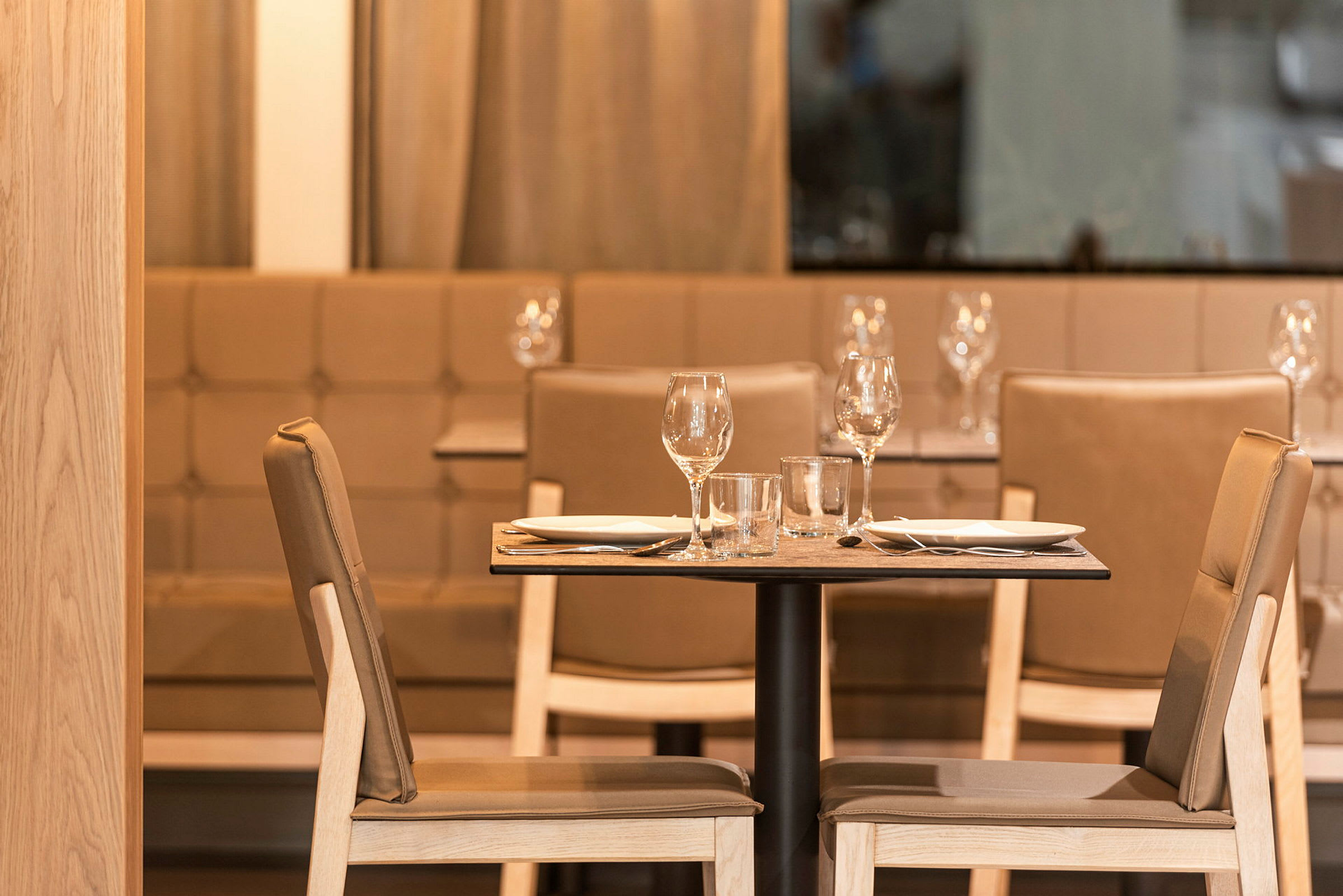 To dækkede stole og et bord i en restaurant. (AI-genereret tekst)