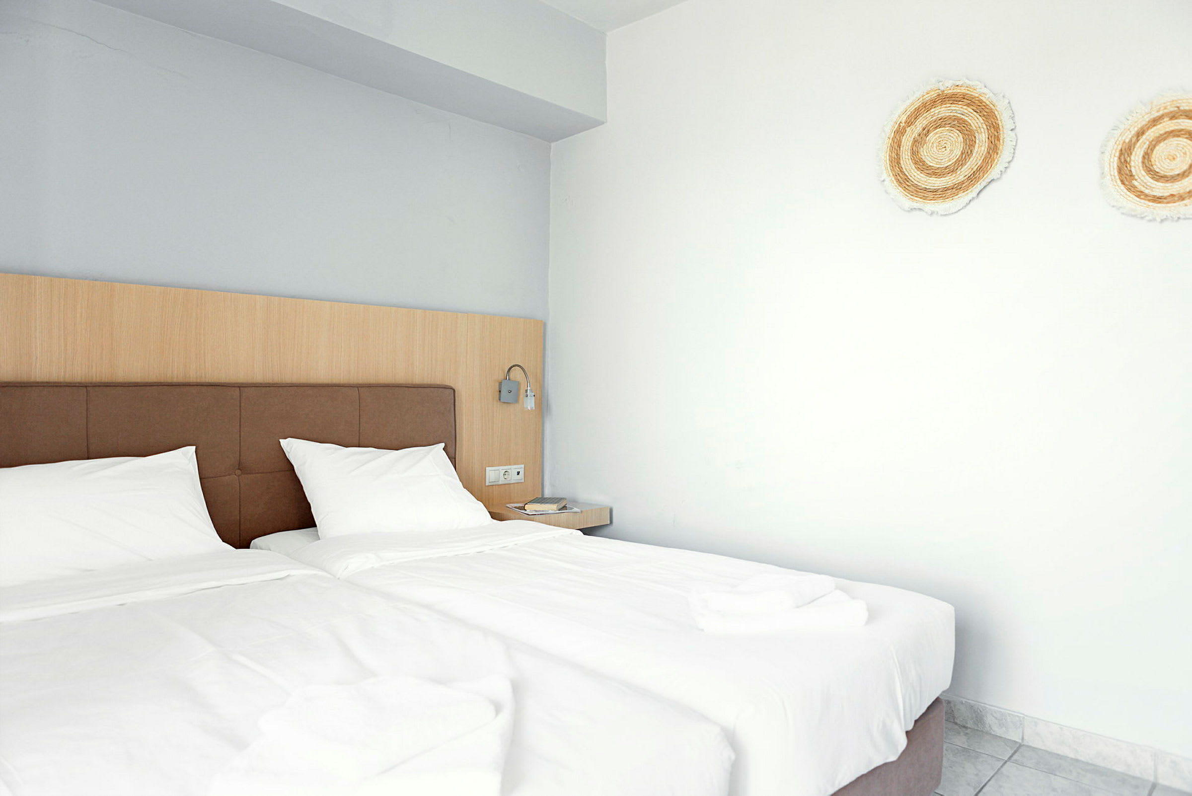 Hotelværelse med to enkeltsenge og dekorationer på væggen. (AI-genereret tekst)